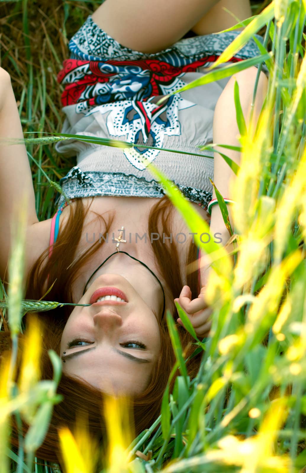 Beautiful young woman lying on the ground in a field