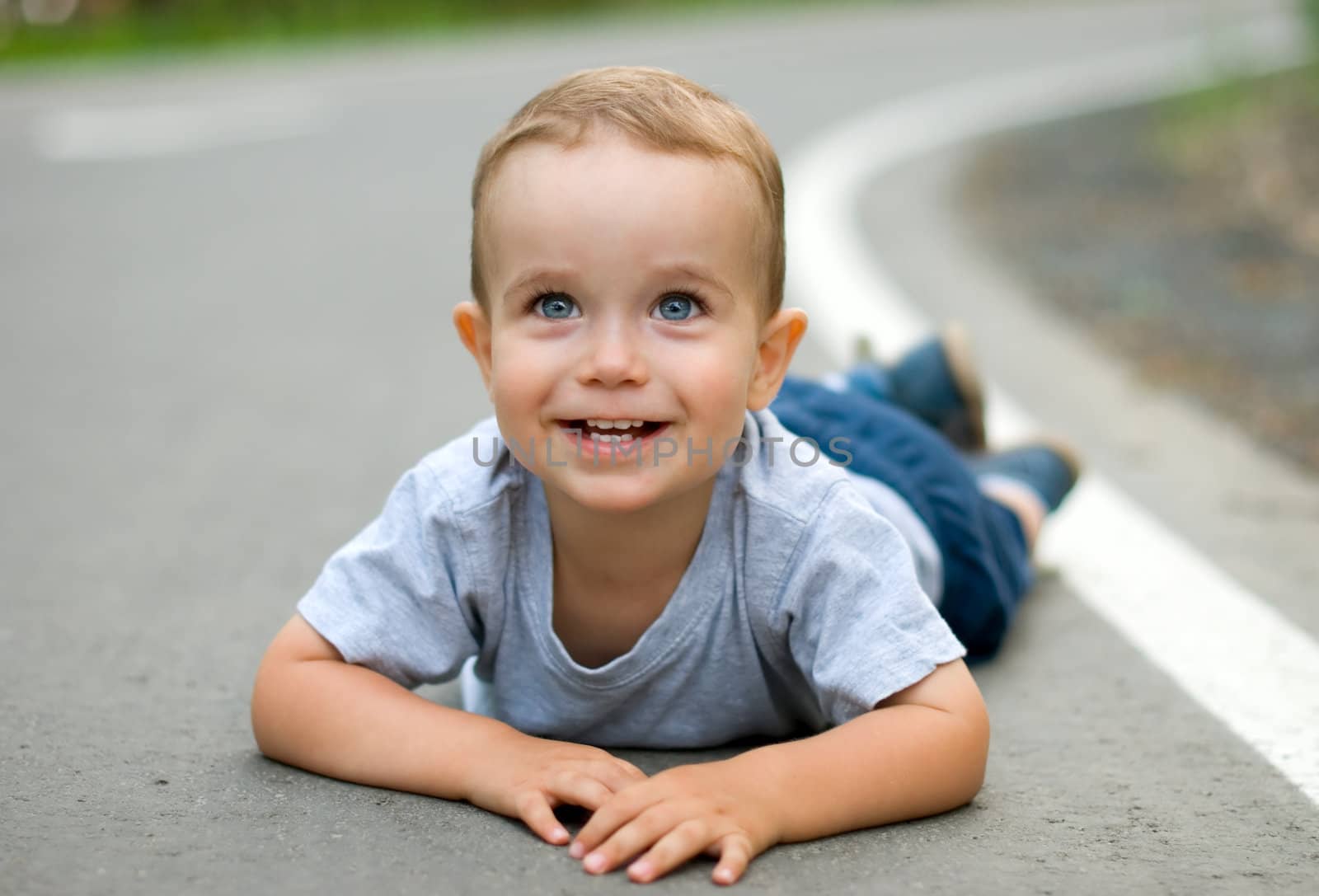 Happy child lying on the pavement