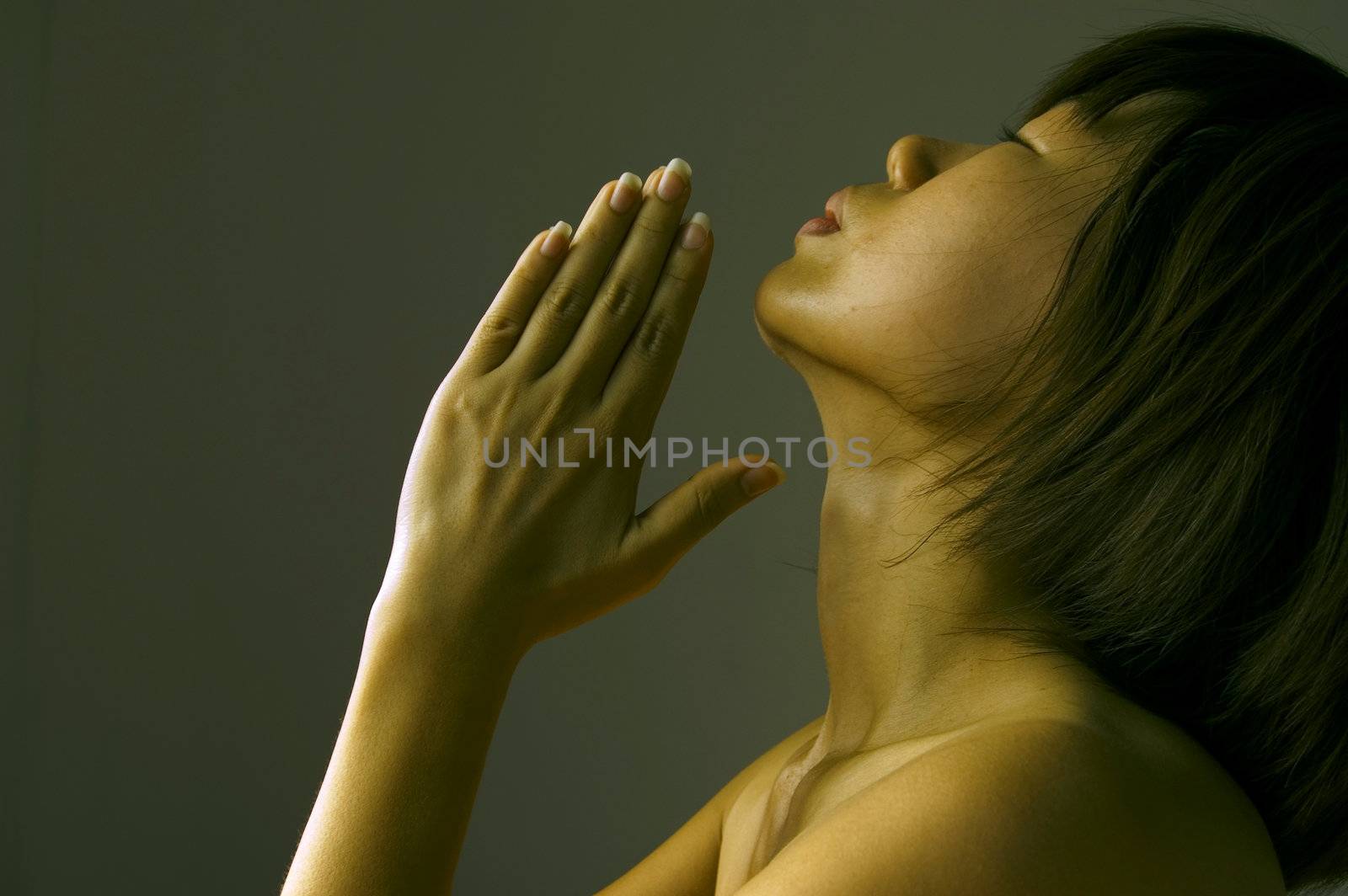 Woman with hands folded in low key 