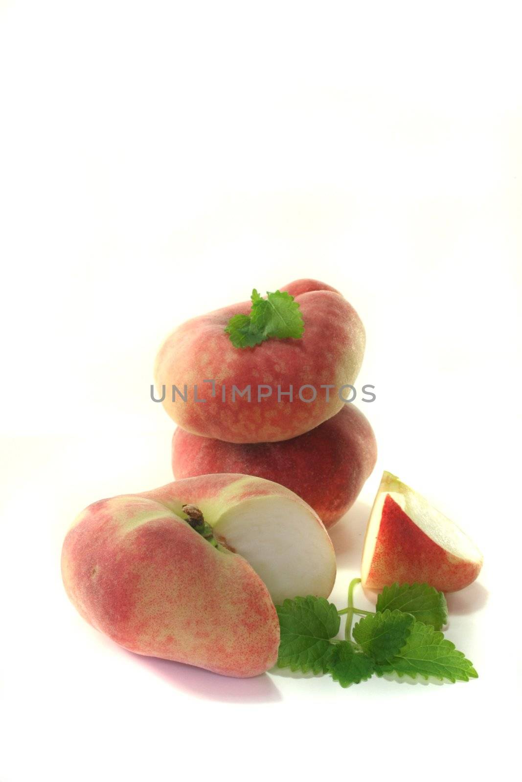 bleed fresh mountain peaches with lemon balm on a white background