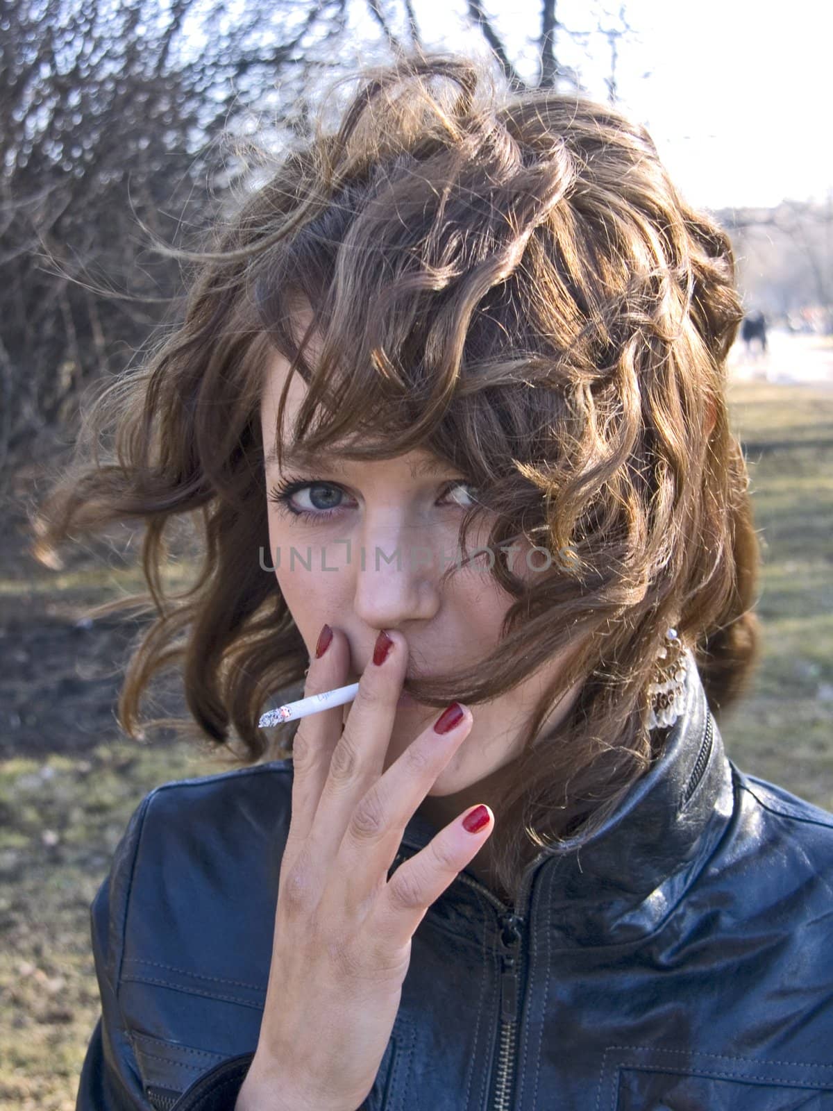 pretty girl smoking in the park in sunny day