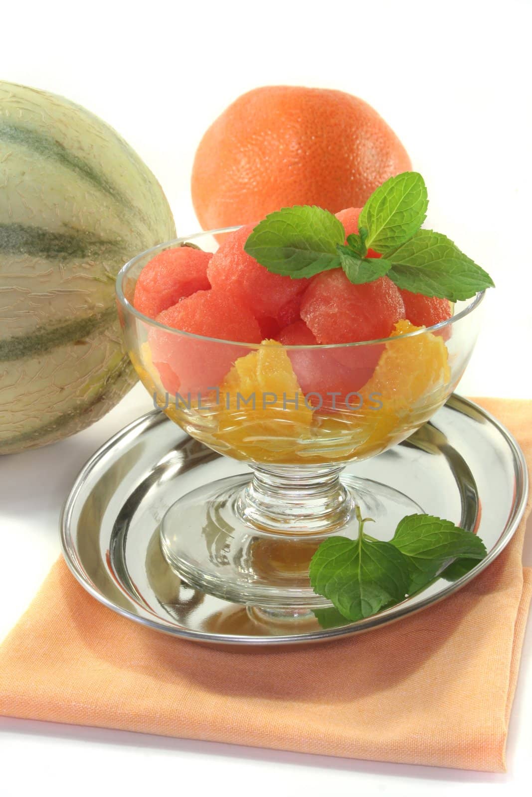 Melon orange salad with fresh peppermint in a bowl
