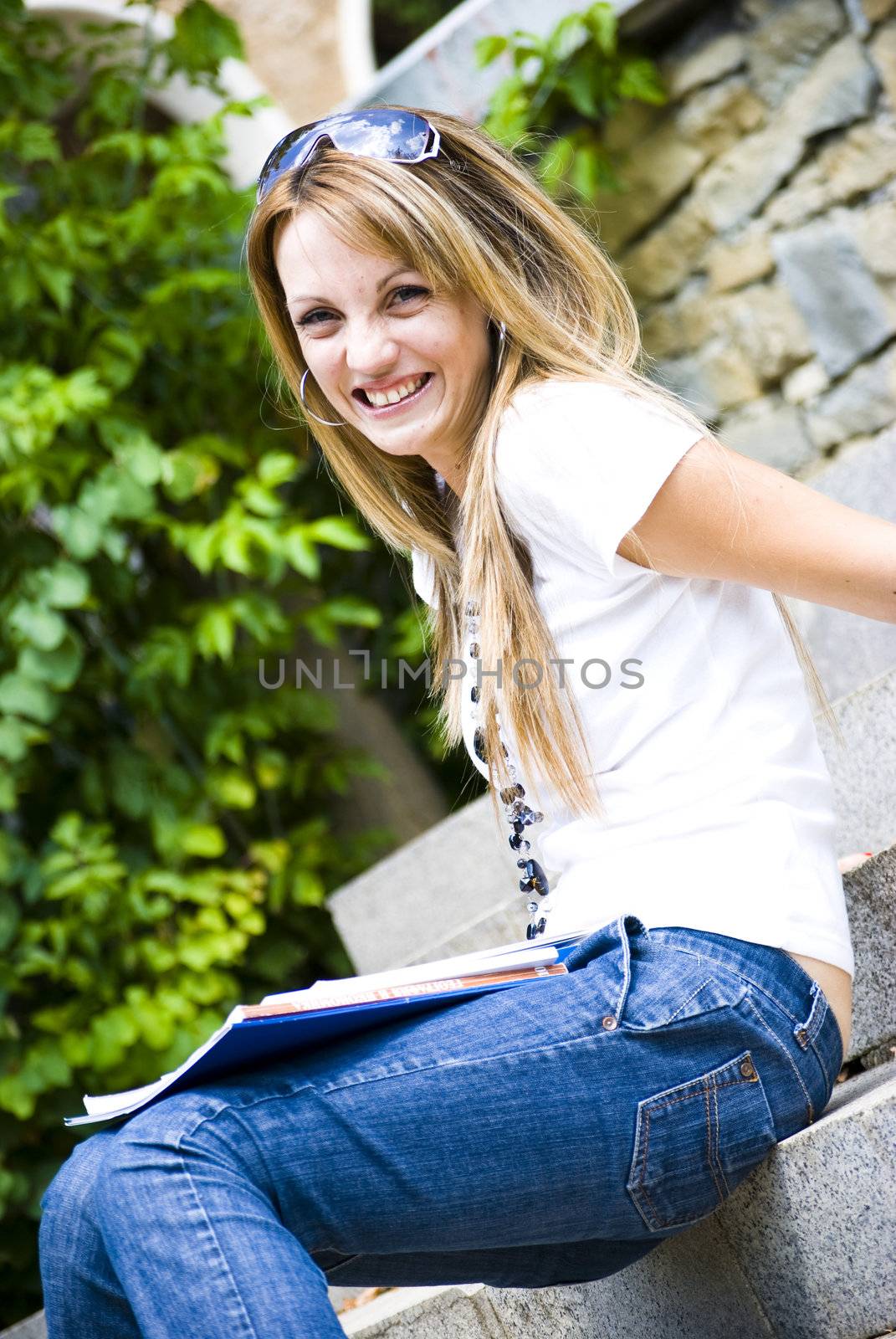 beautiful young woman with books and flower outdoor