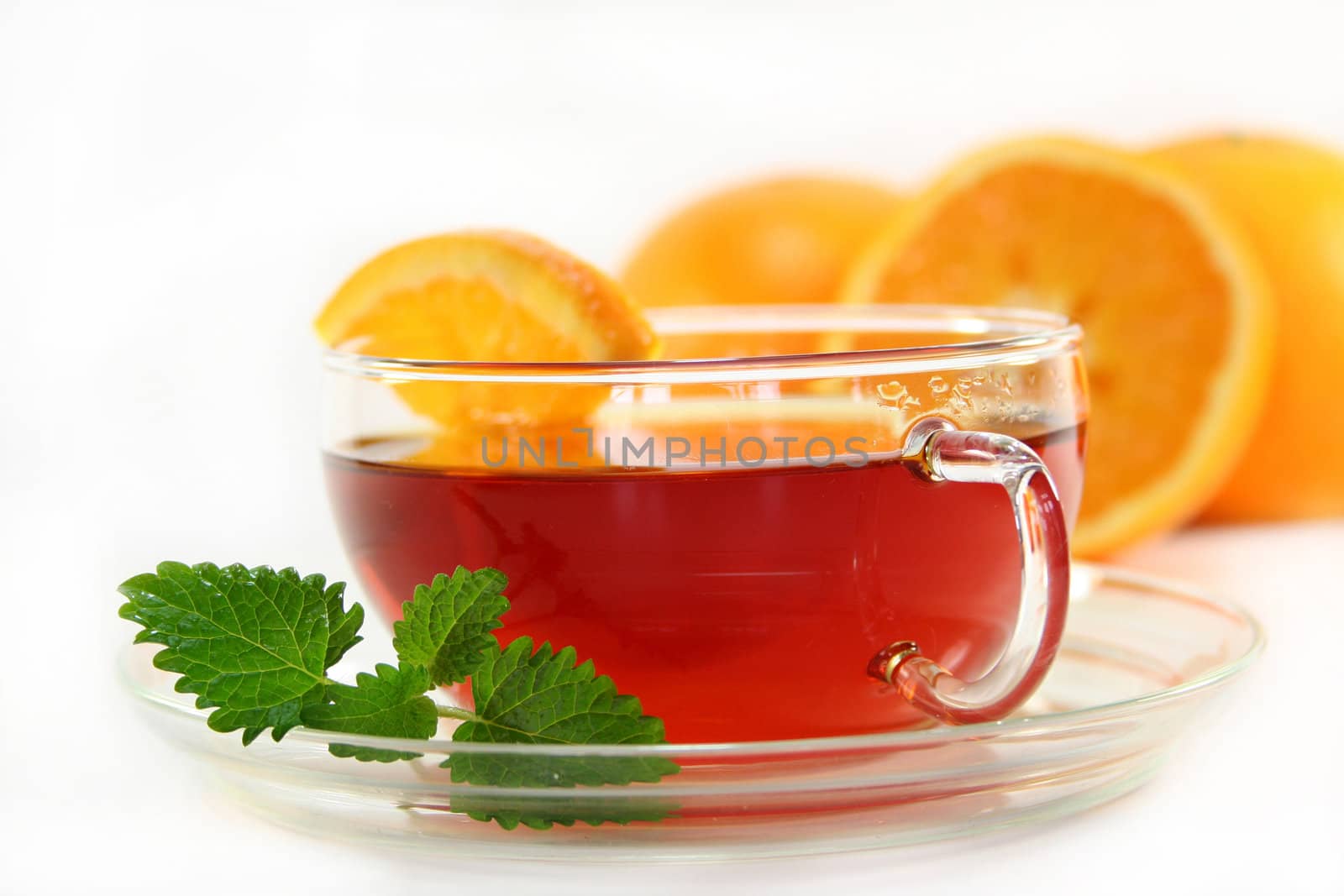 a cup of orange tea with fresh oranges