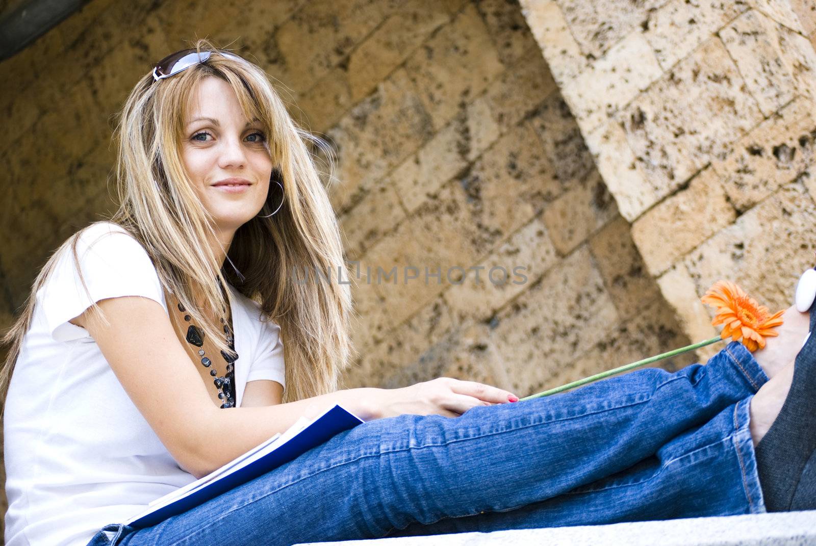 beautiful young woman with books and flower outdoor