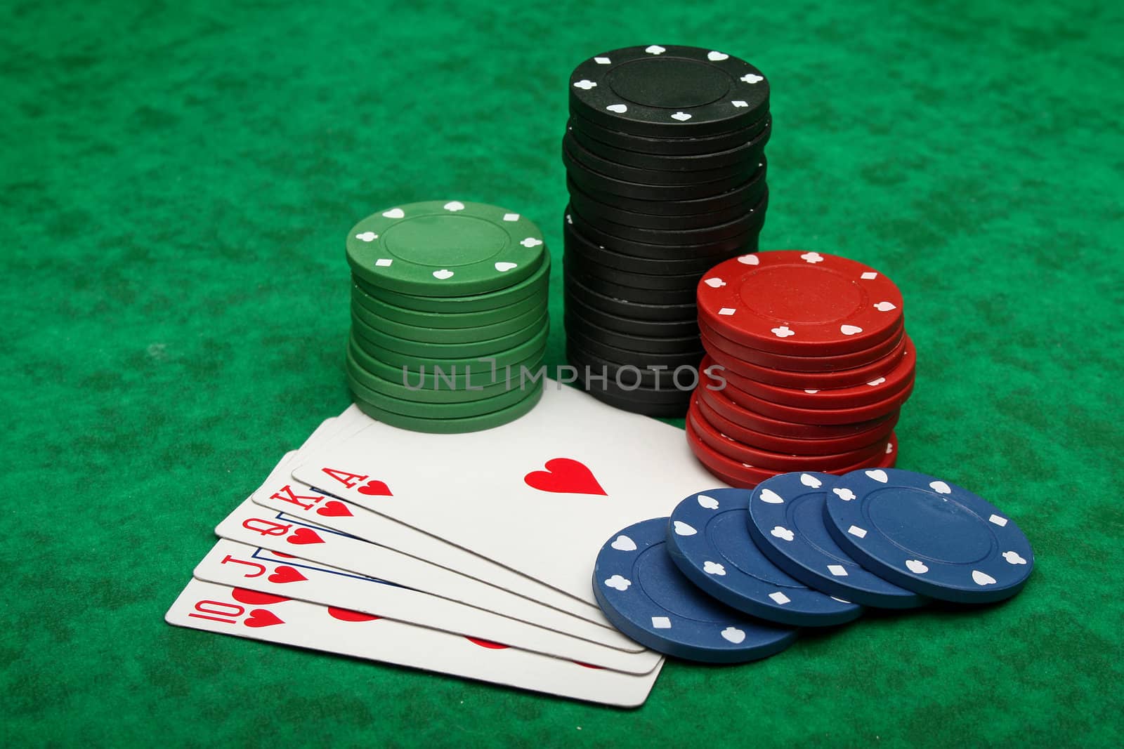 Royal Flush with gambling chips over green felt