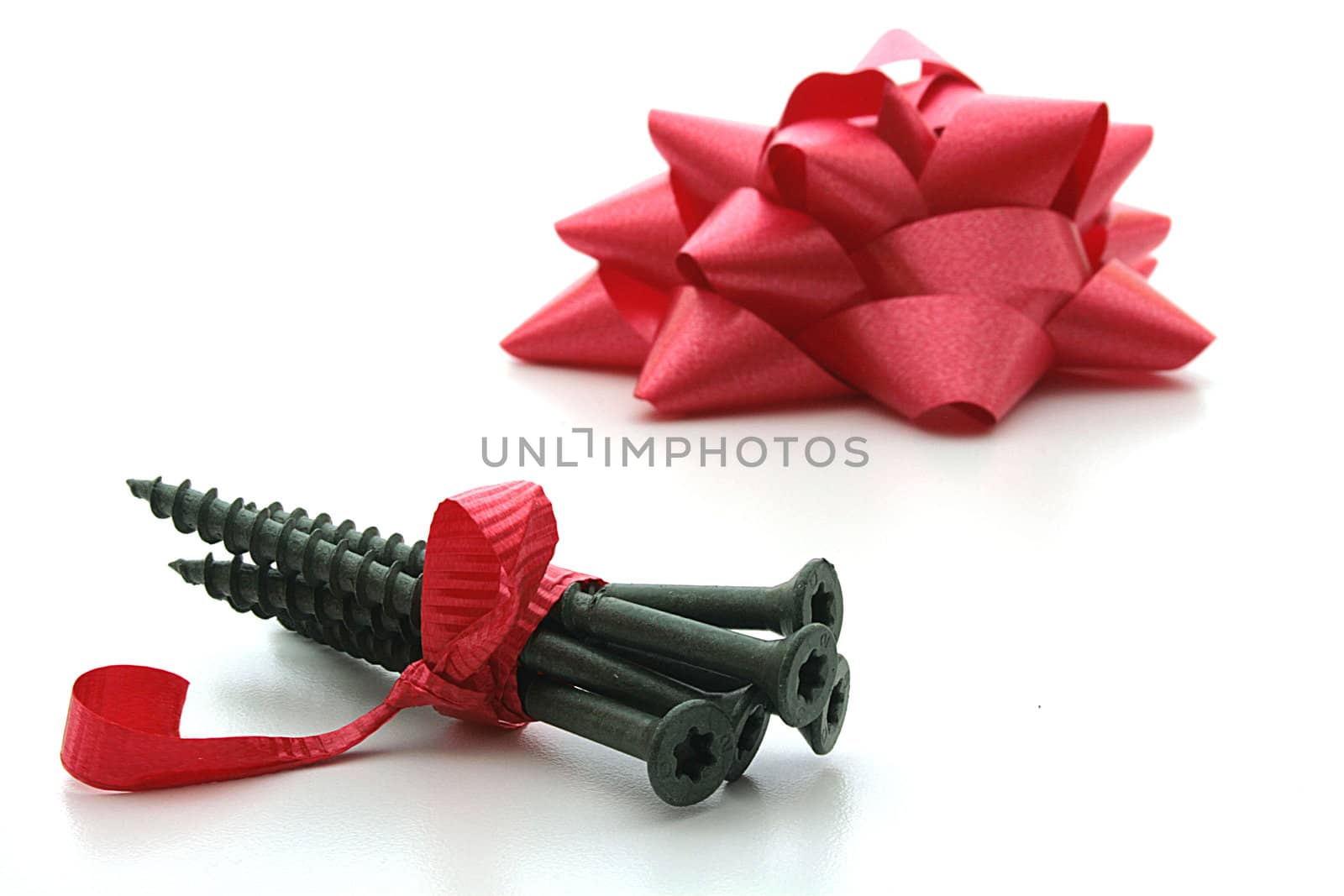 Screws tied up by a red ribbon and a bow in a gift to the father.