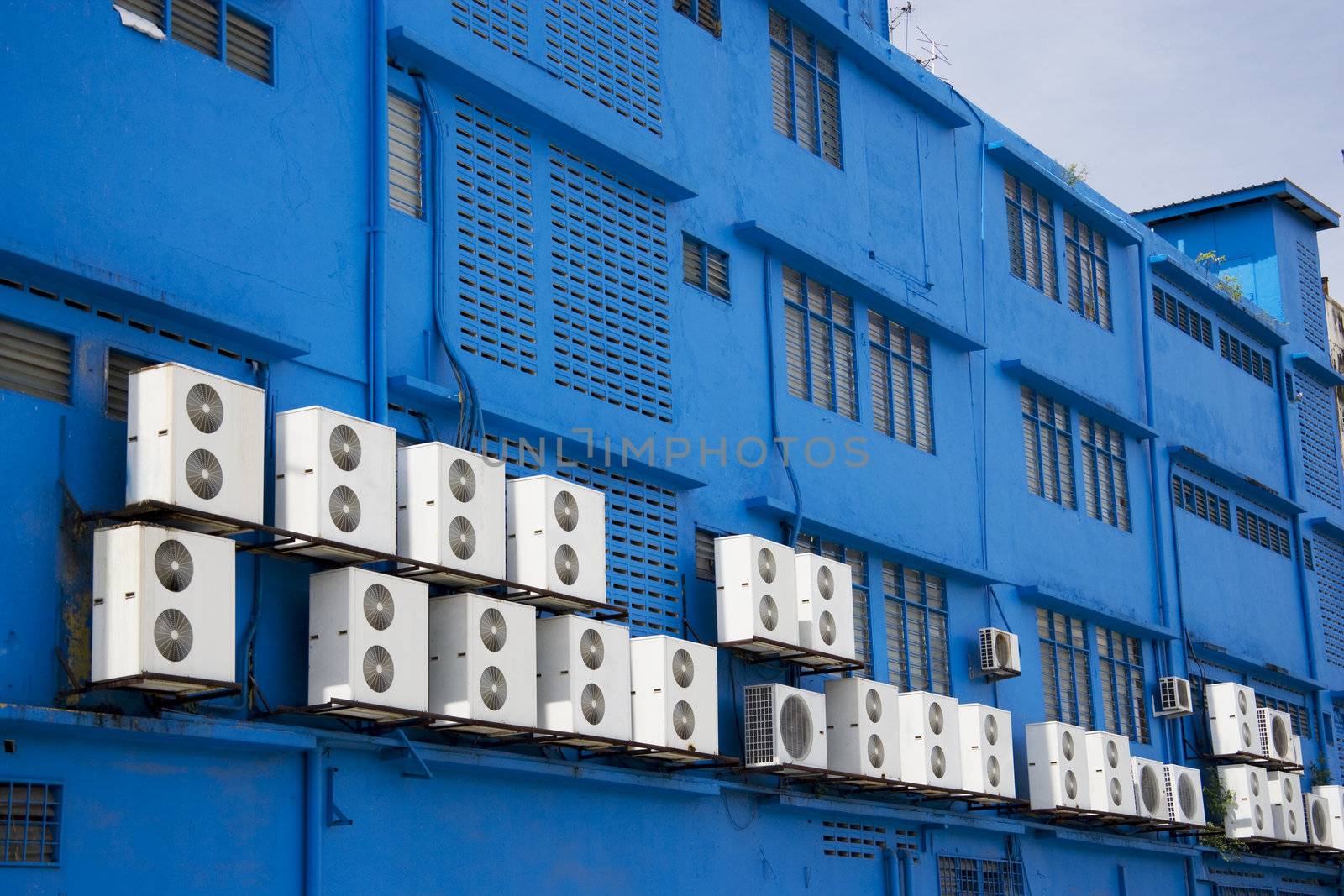 Image of aircondition compressors on a blue building.