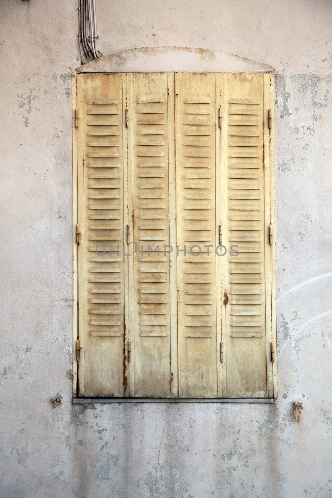 Closed yellow shutters and worn dirty building