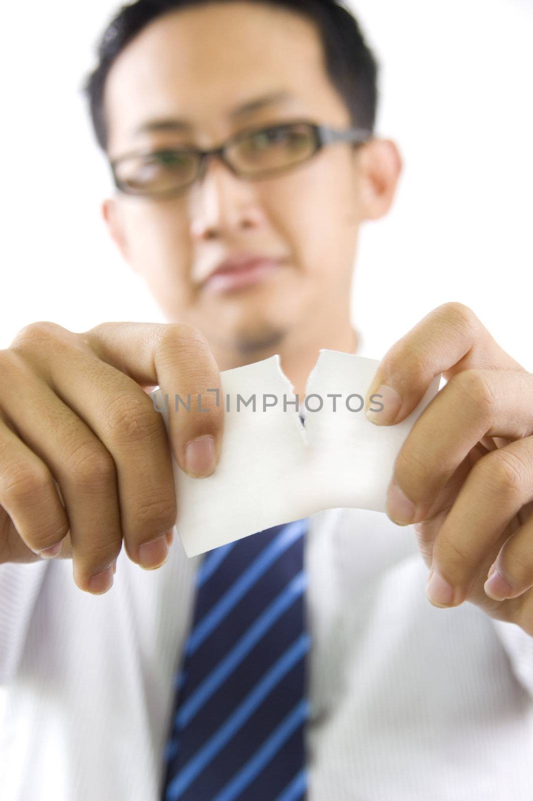 Businessman tear to pieces sheets of card 