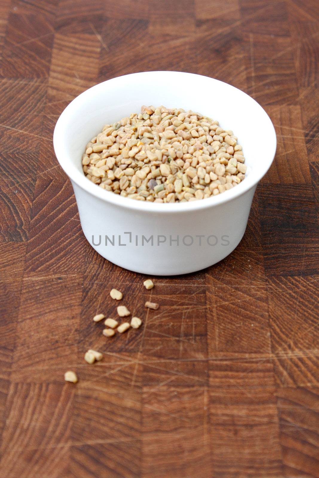 Fenugreek seeds on a brown surface