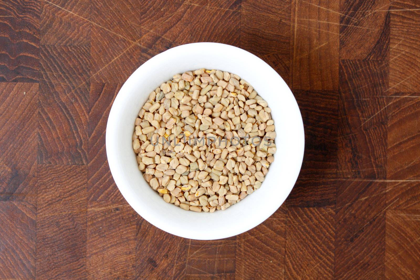 Fenugreek seeds on a brown surface