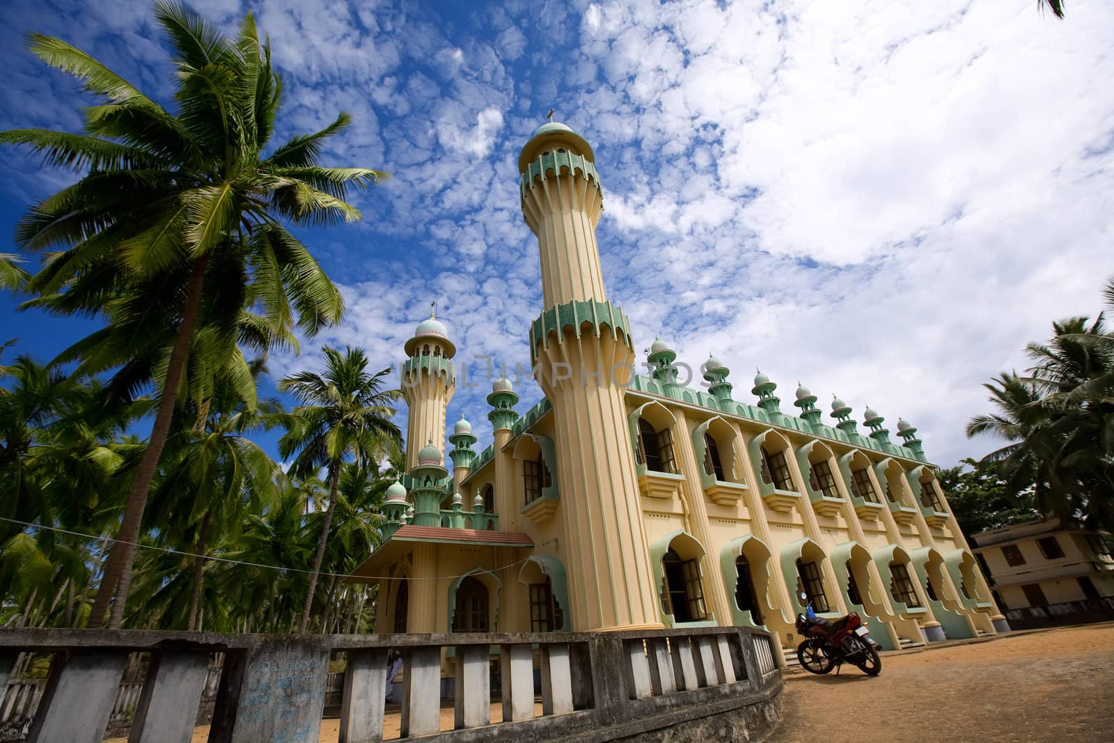 Antique islamic mosque in the green palms on the beach