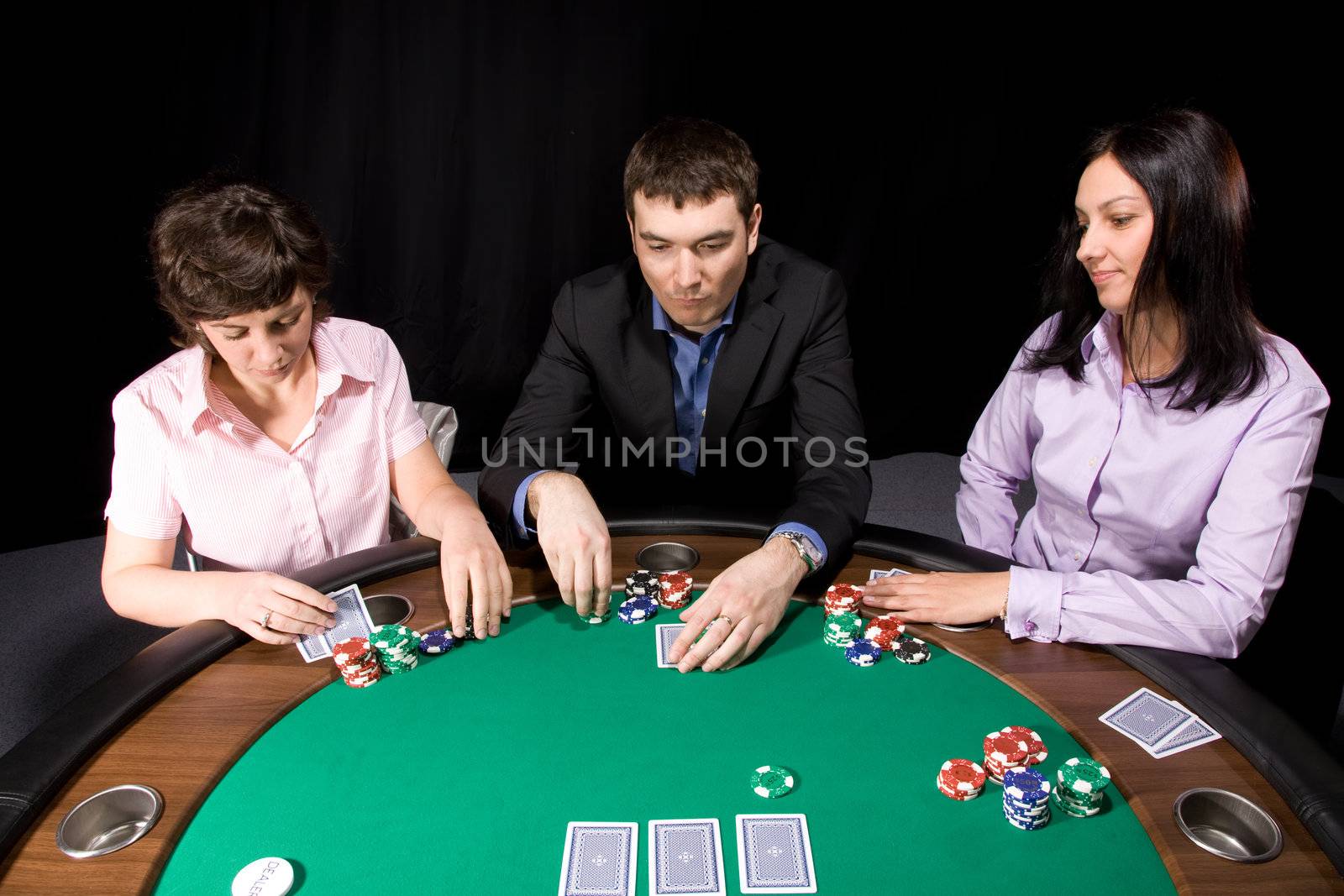 Company of friends having fun in the casino poker table