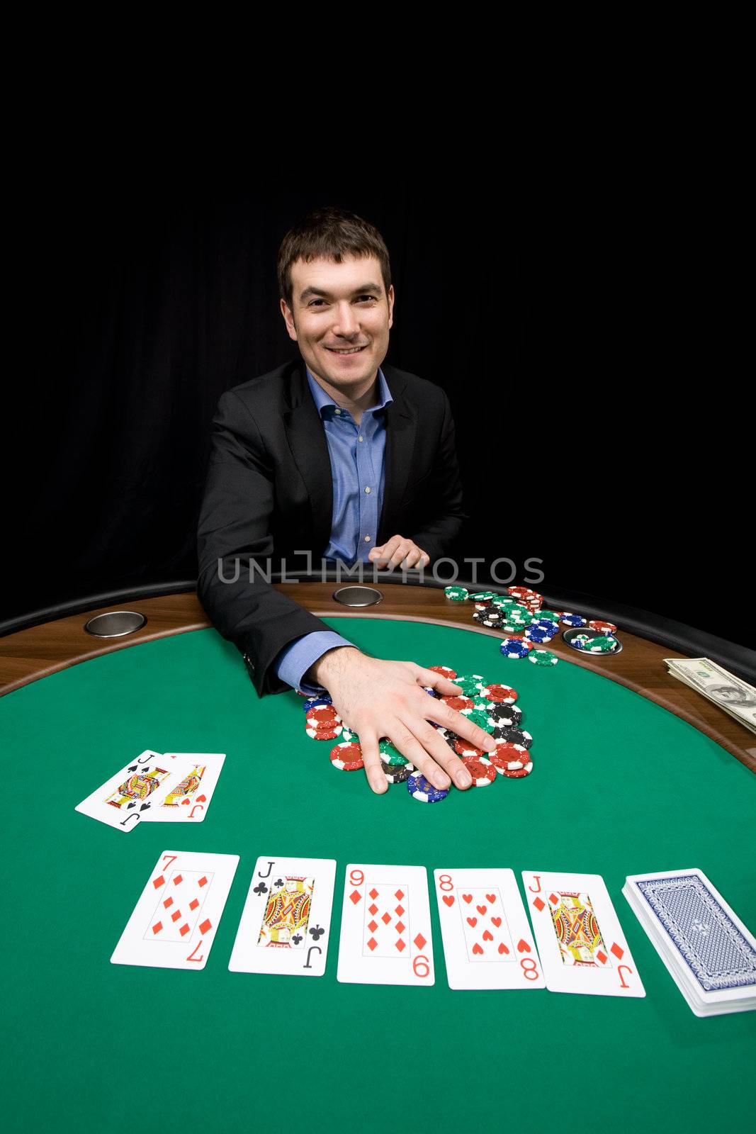 Smiling caucasian man win chips in casino poker