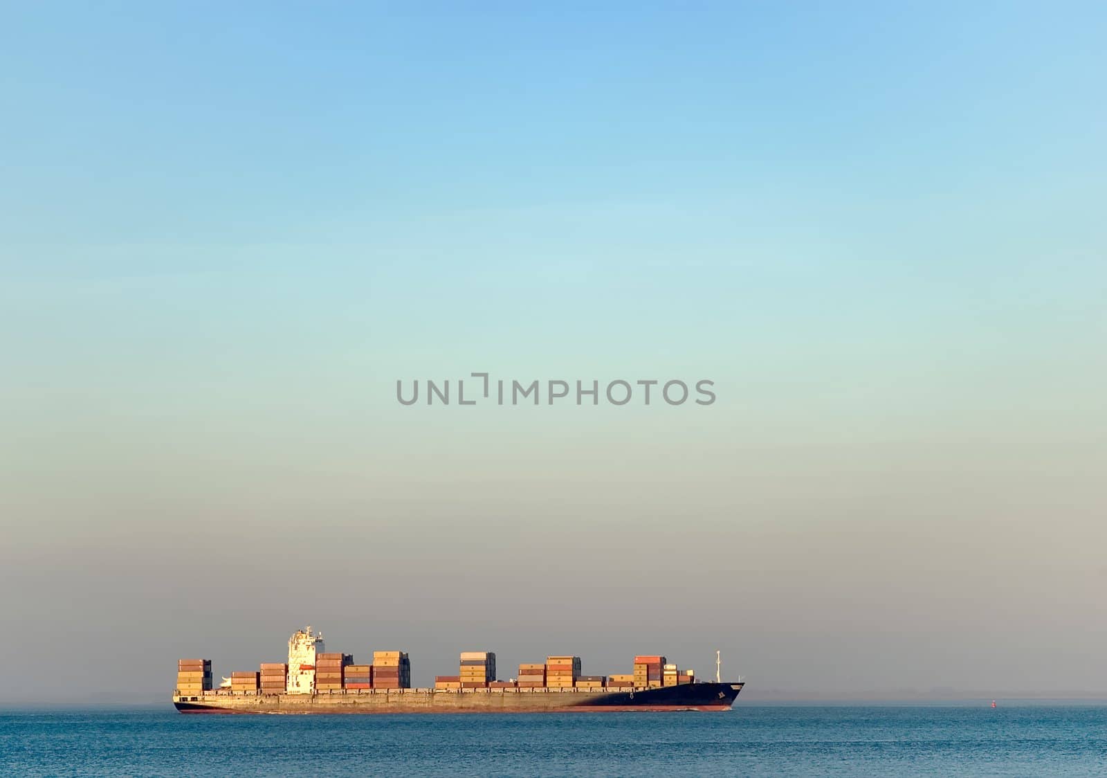 loaded ship transporting containers on blue water