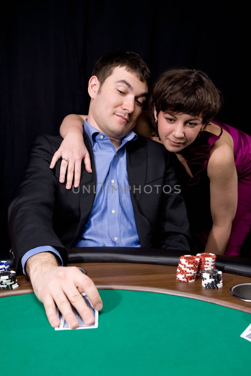 Couple in the casino playing poker on green felt