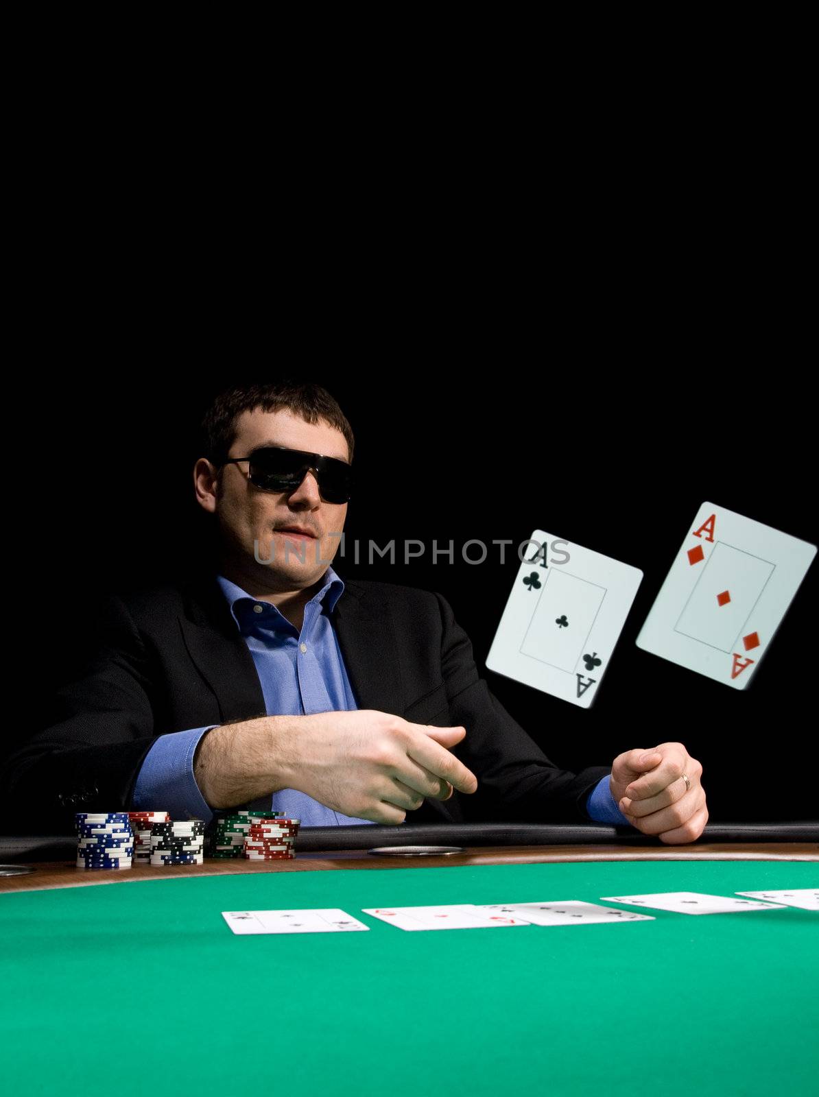 Stylish man in black suit folds two aces in casino poker at Las Vegas