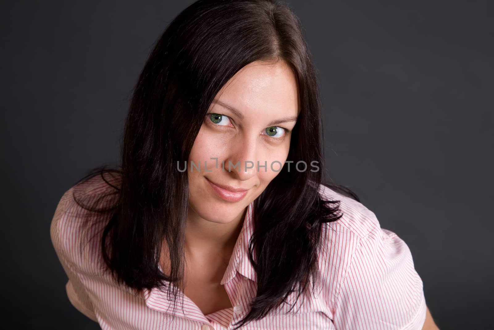 Smiling woman closeup portrait over gray in studio