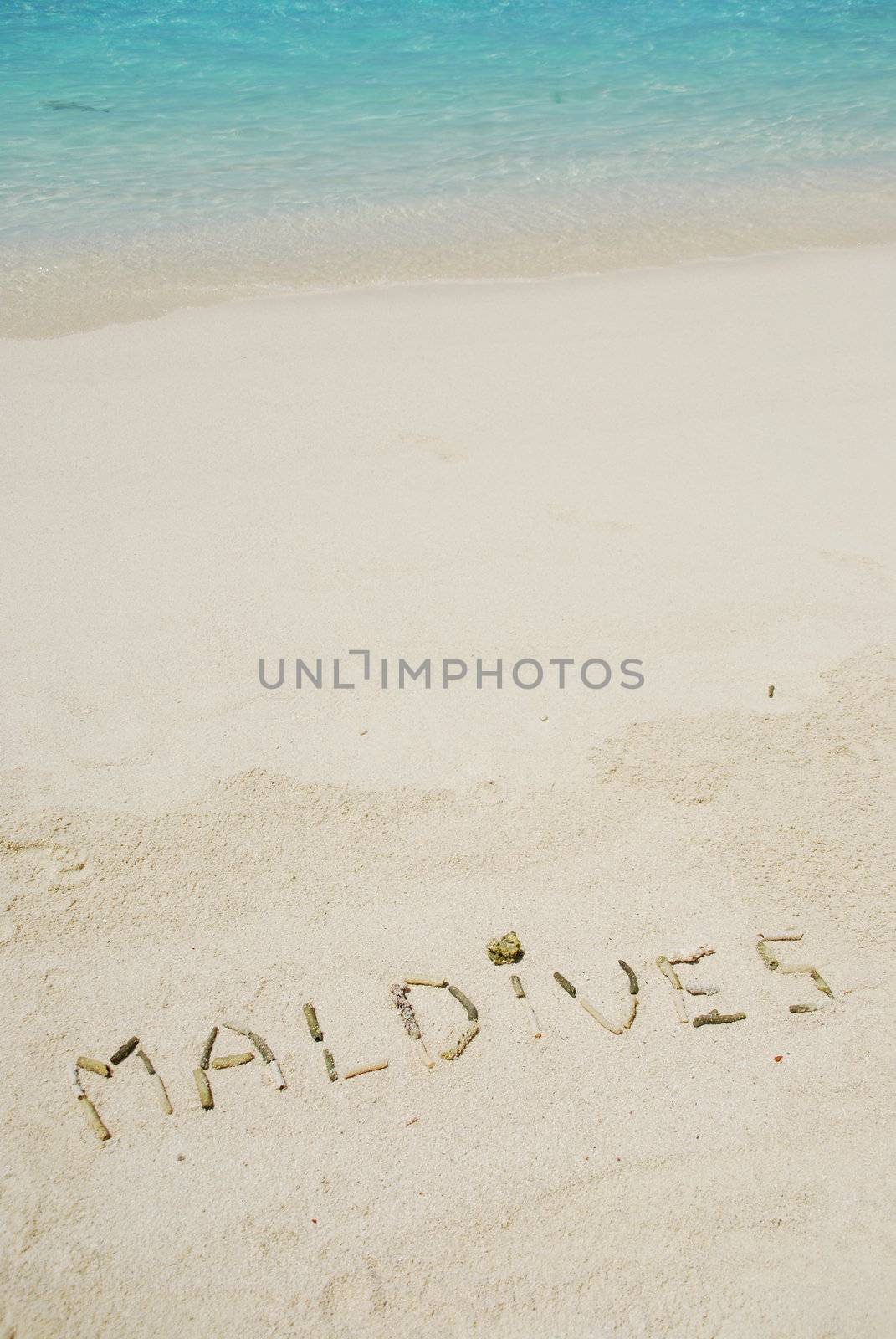 Maldives note written on a white sandy beach