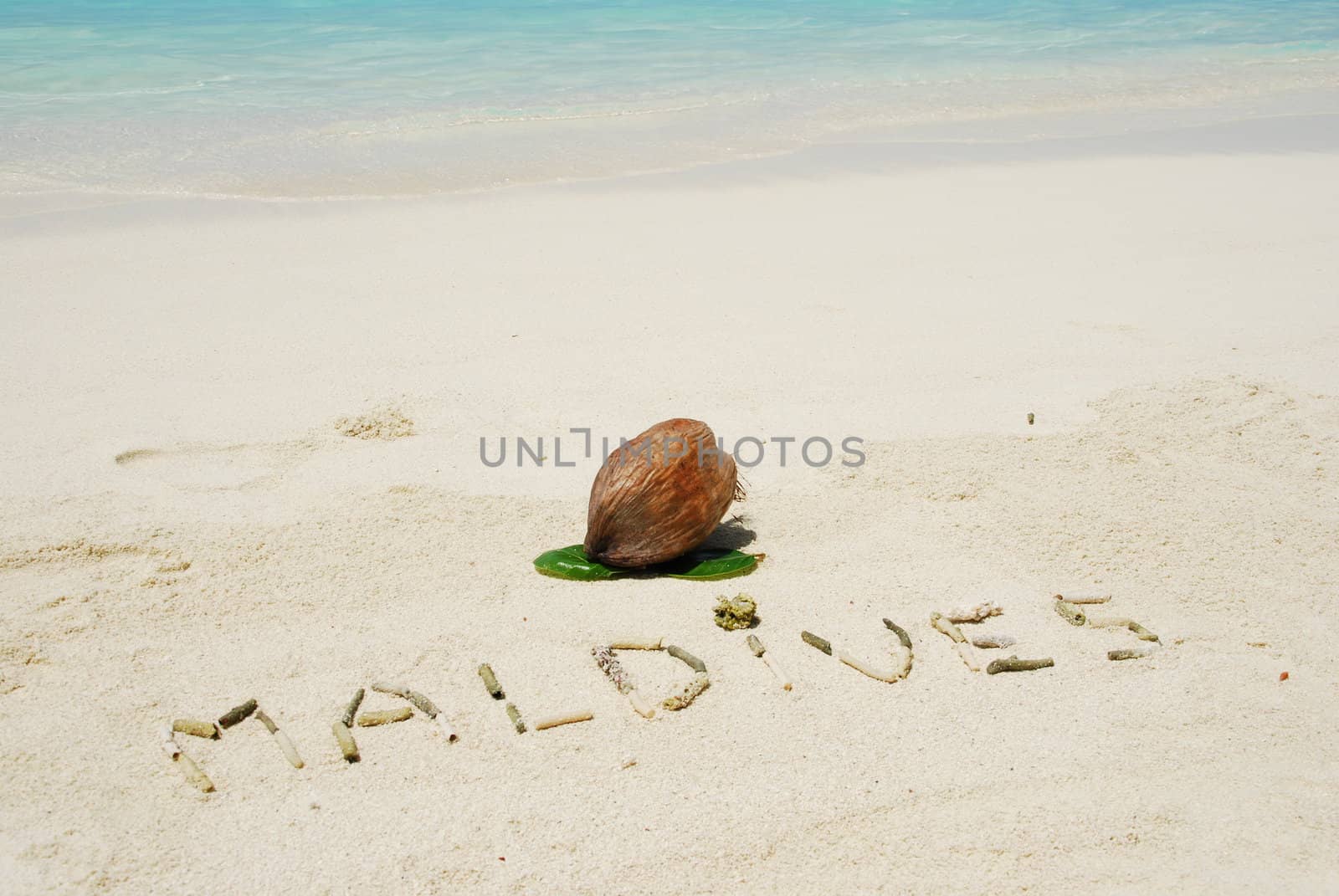 Maldives written in a sandy tropical beach and coconut fruit by luissantos84