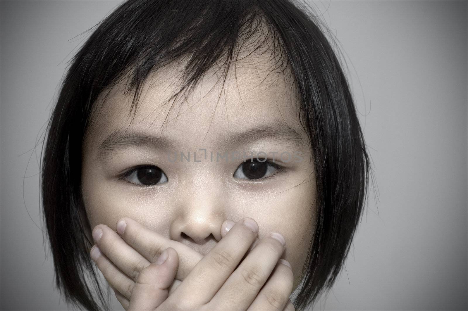 little girl covering her mouth, crime witness concept.
