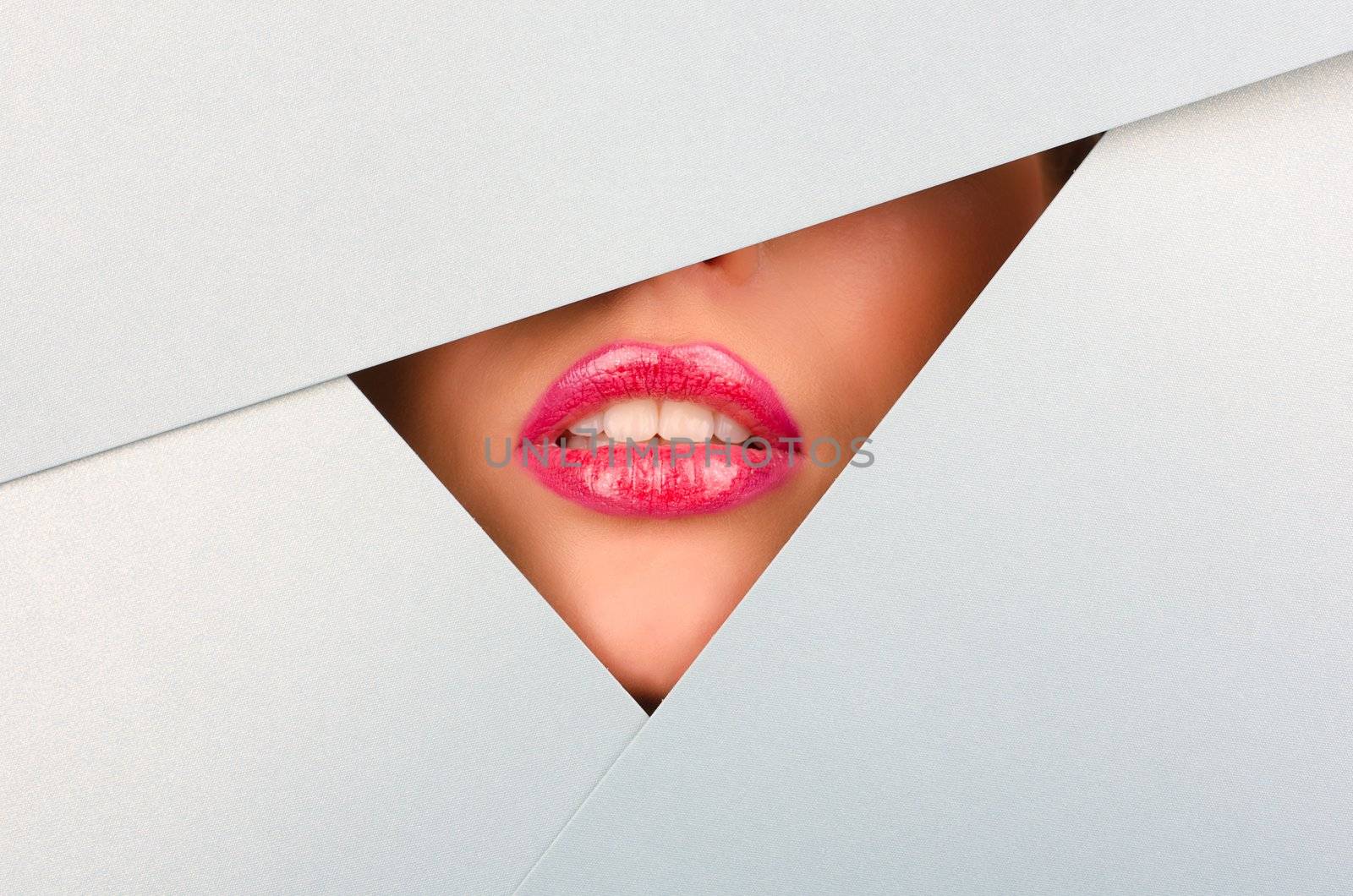 Beautiful female lips closeup behind silver paper background