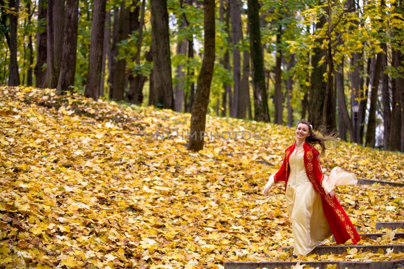 lady in medieval red dress in the autumn forest
