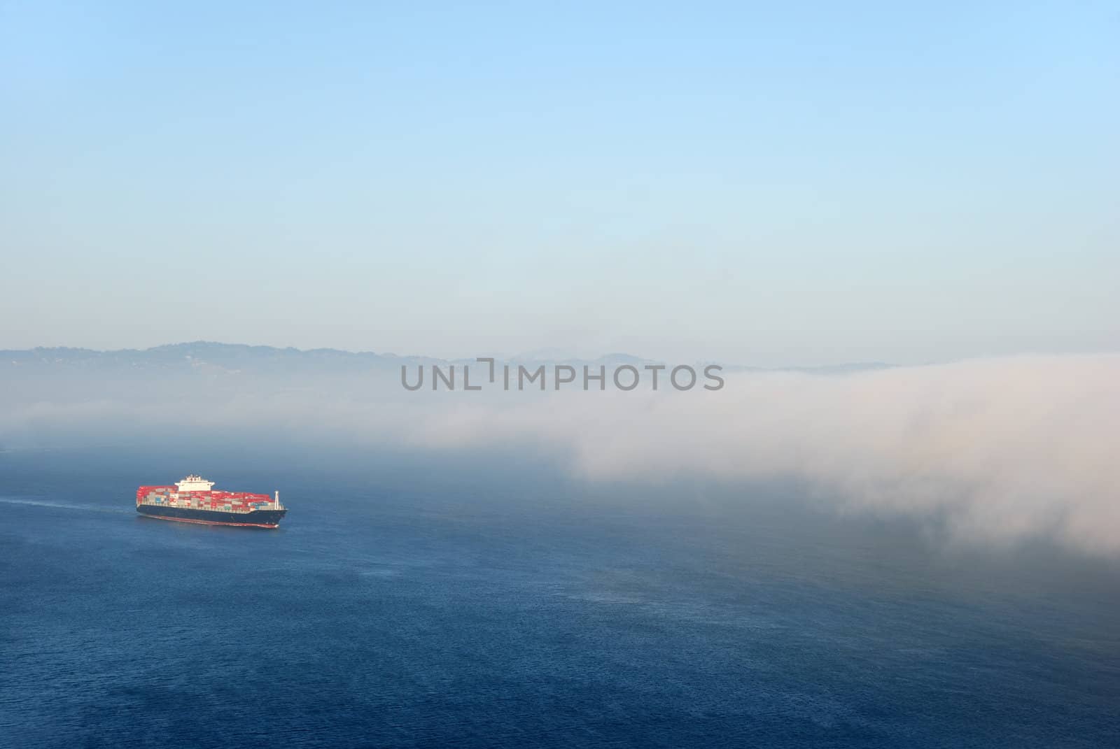 A tanker carrying containers flowing into the fog.