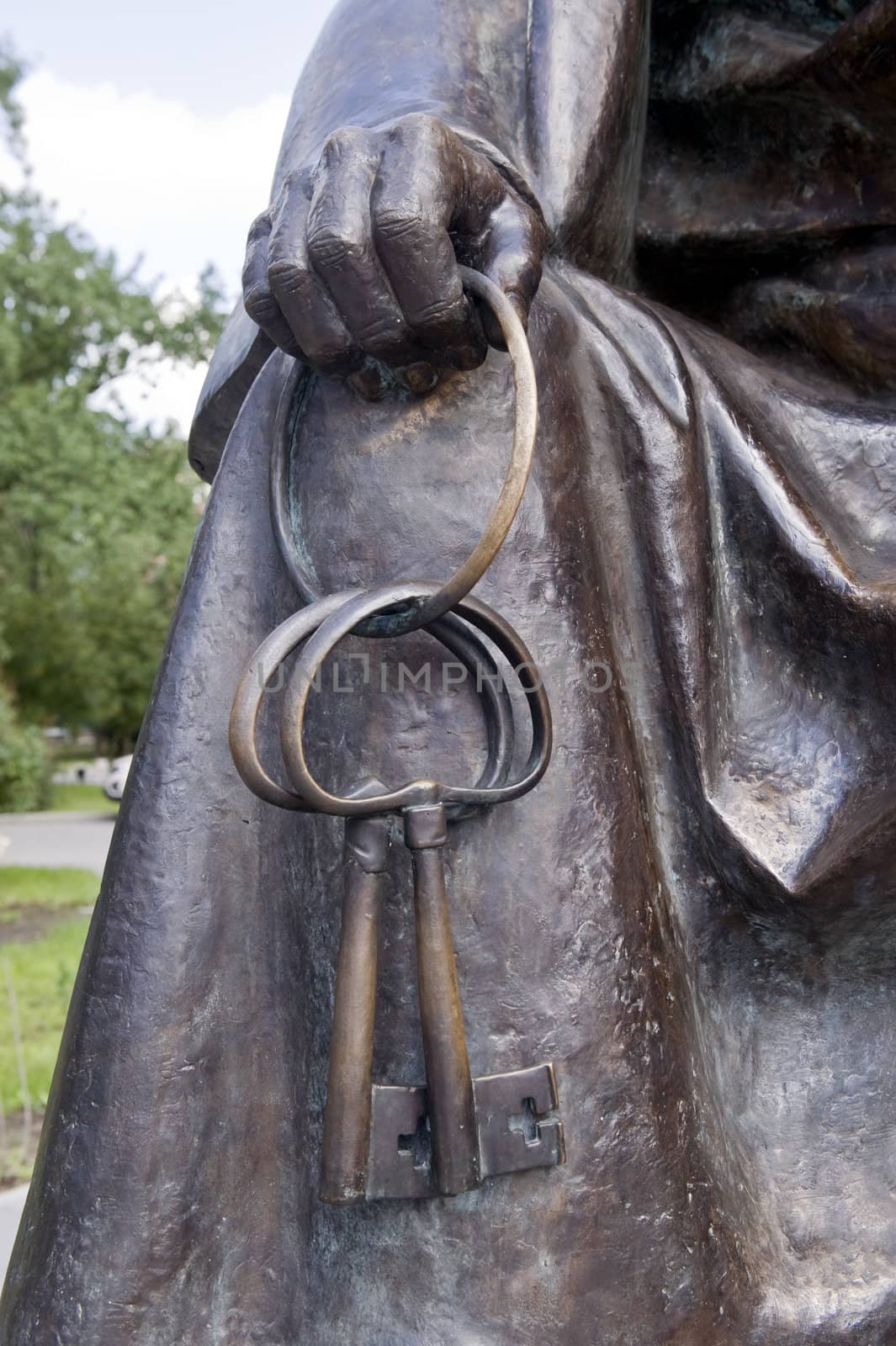 Element of a bronze sculpture. The hand holds two keys.