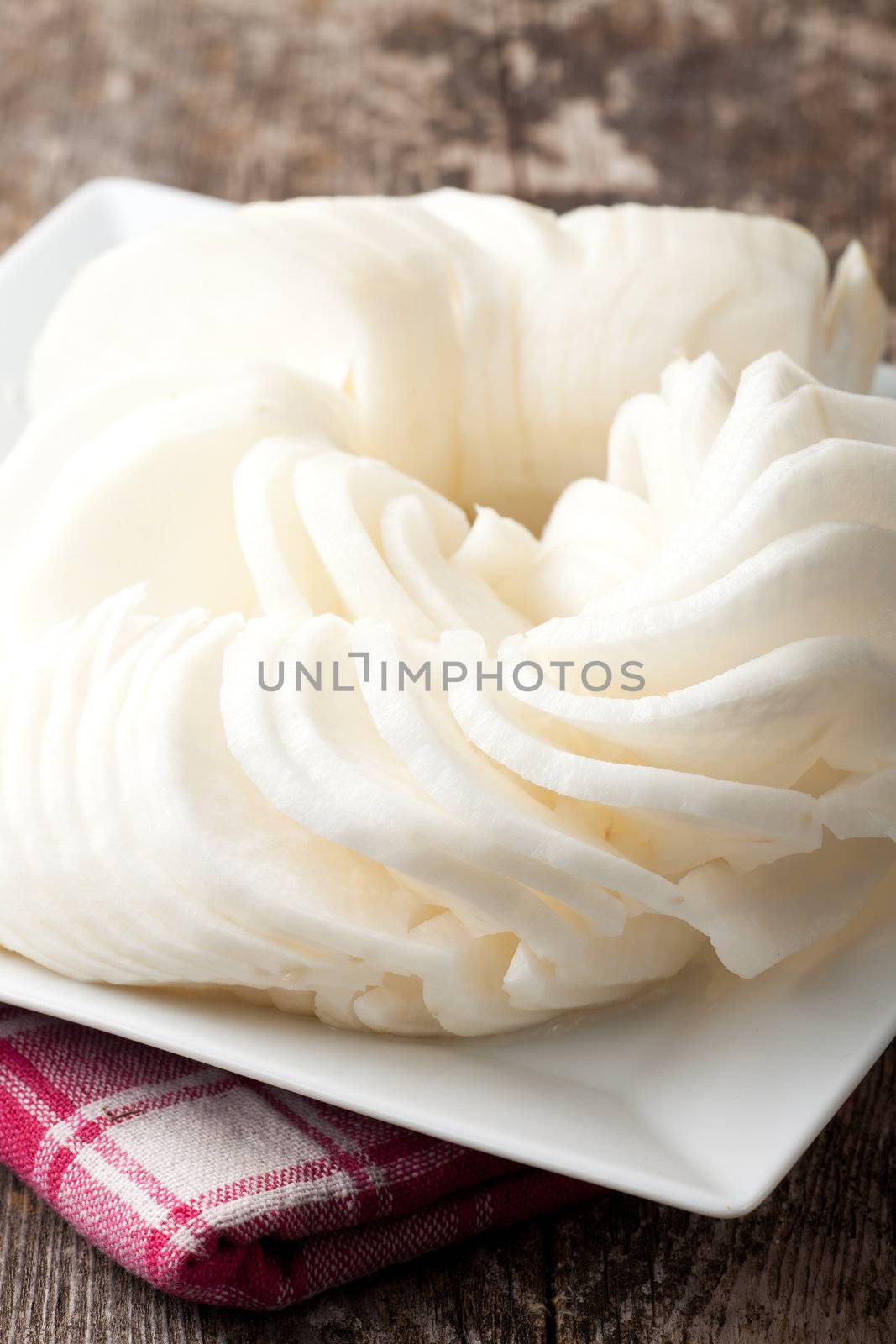 sliced white radish on a plate by bernjuer