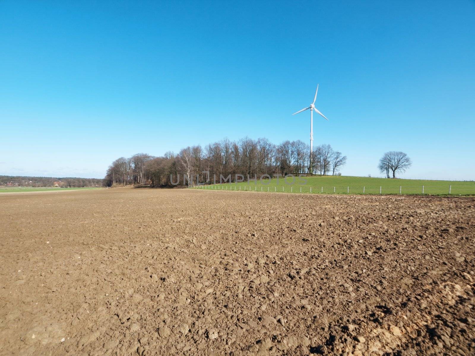 Wind turbine on a clear blue sky  close to a forest