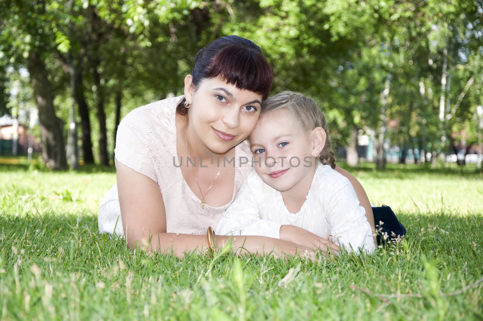 The portrait of the baby and mother in the park, on the green grass