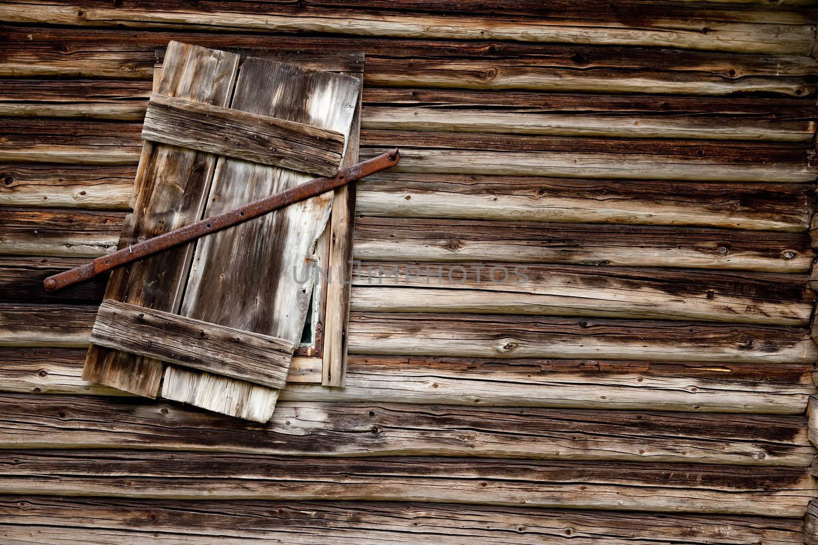 A weathered log cabin background texture with old window