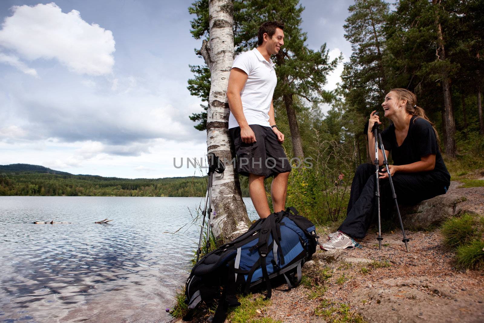 A couple on a camping trip - taking a break by a lake