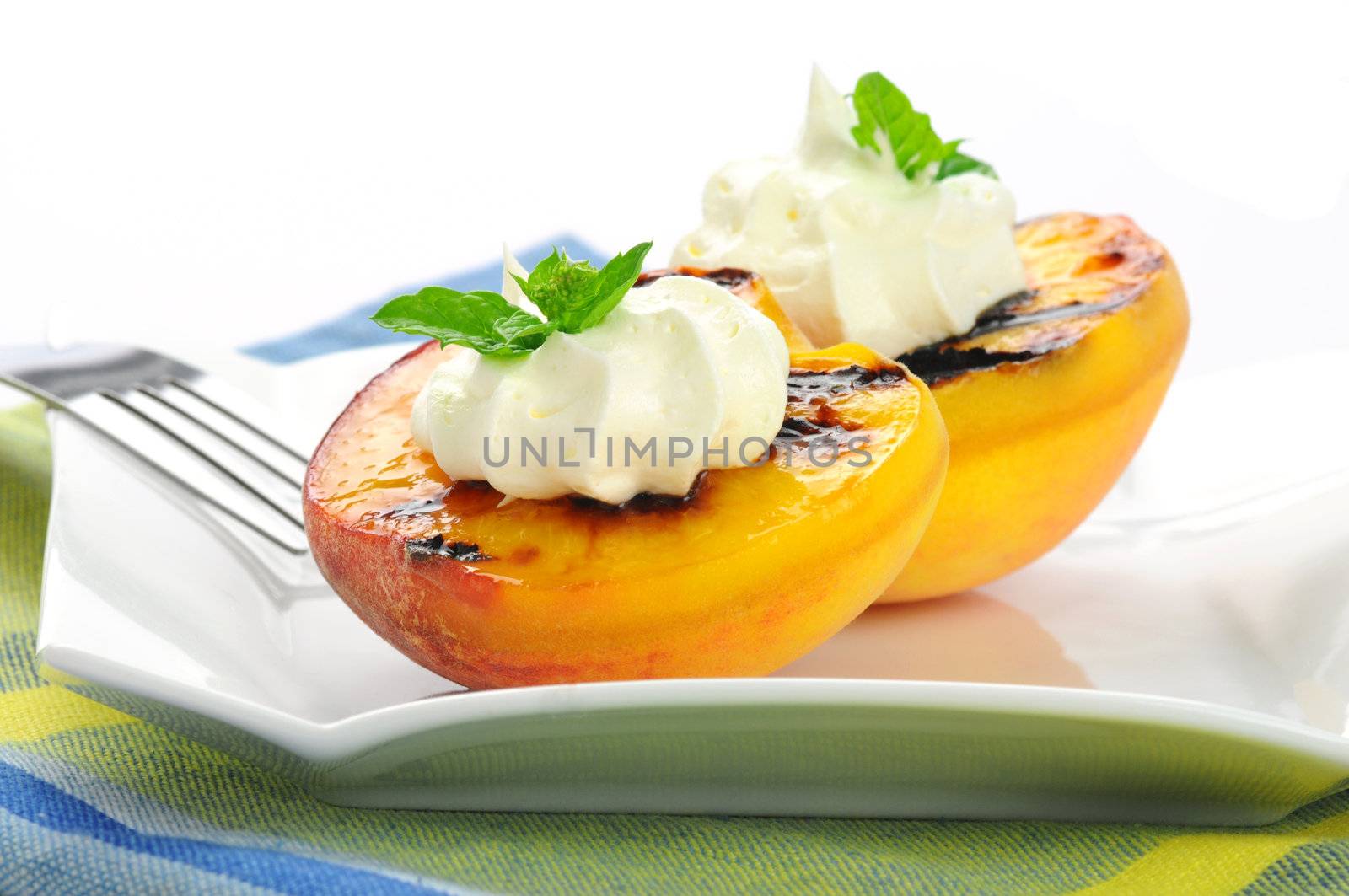 Delicious grilled peaches served with whipped cream.