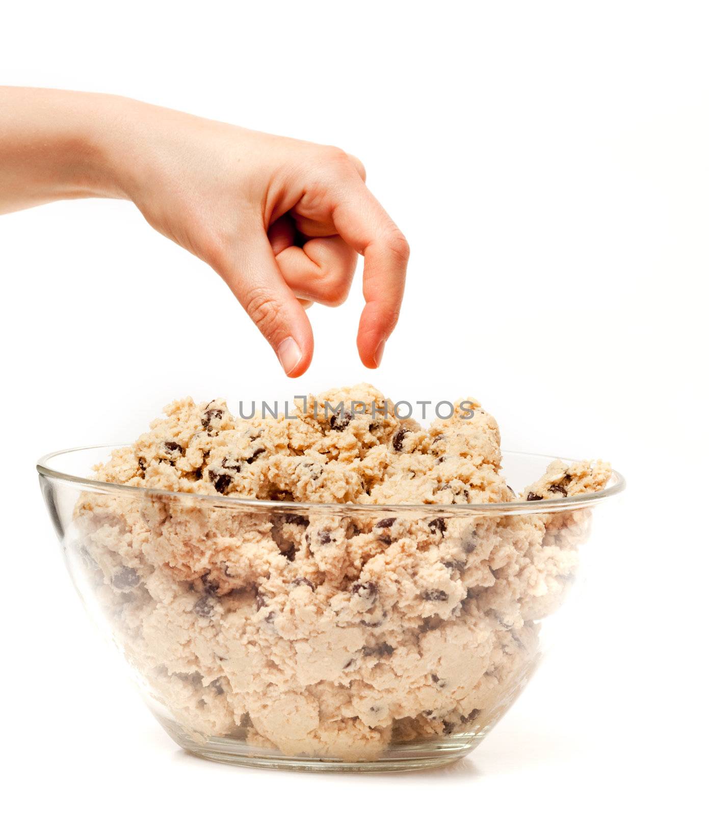 A hand reaching for a bowl of raw cookie dough