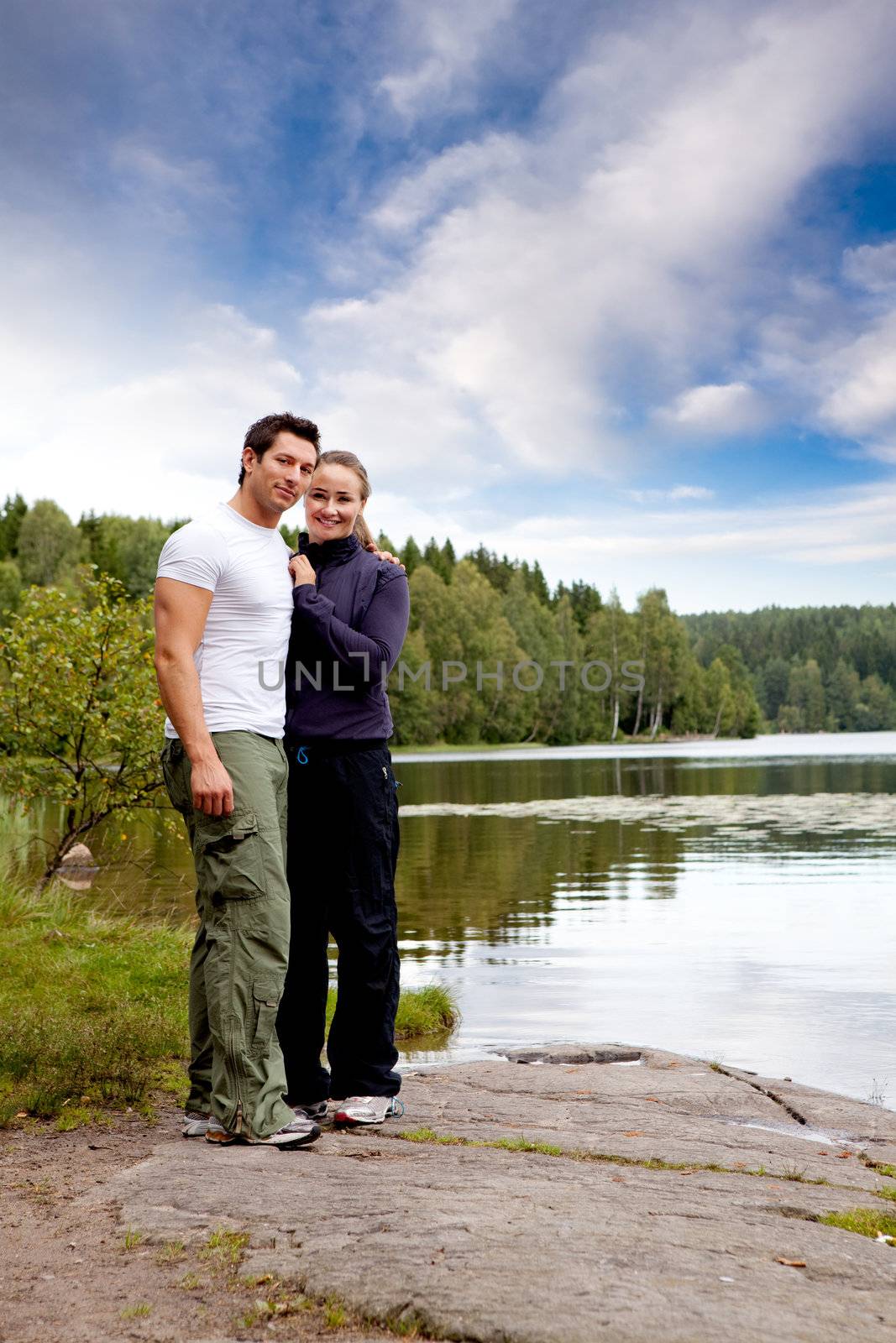 A outdoors couple portrait by a lake and forest