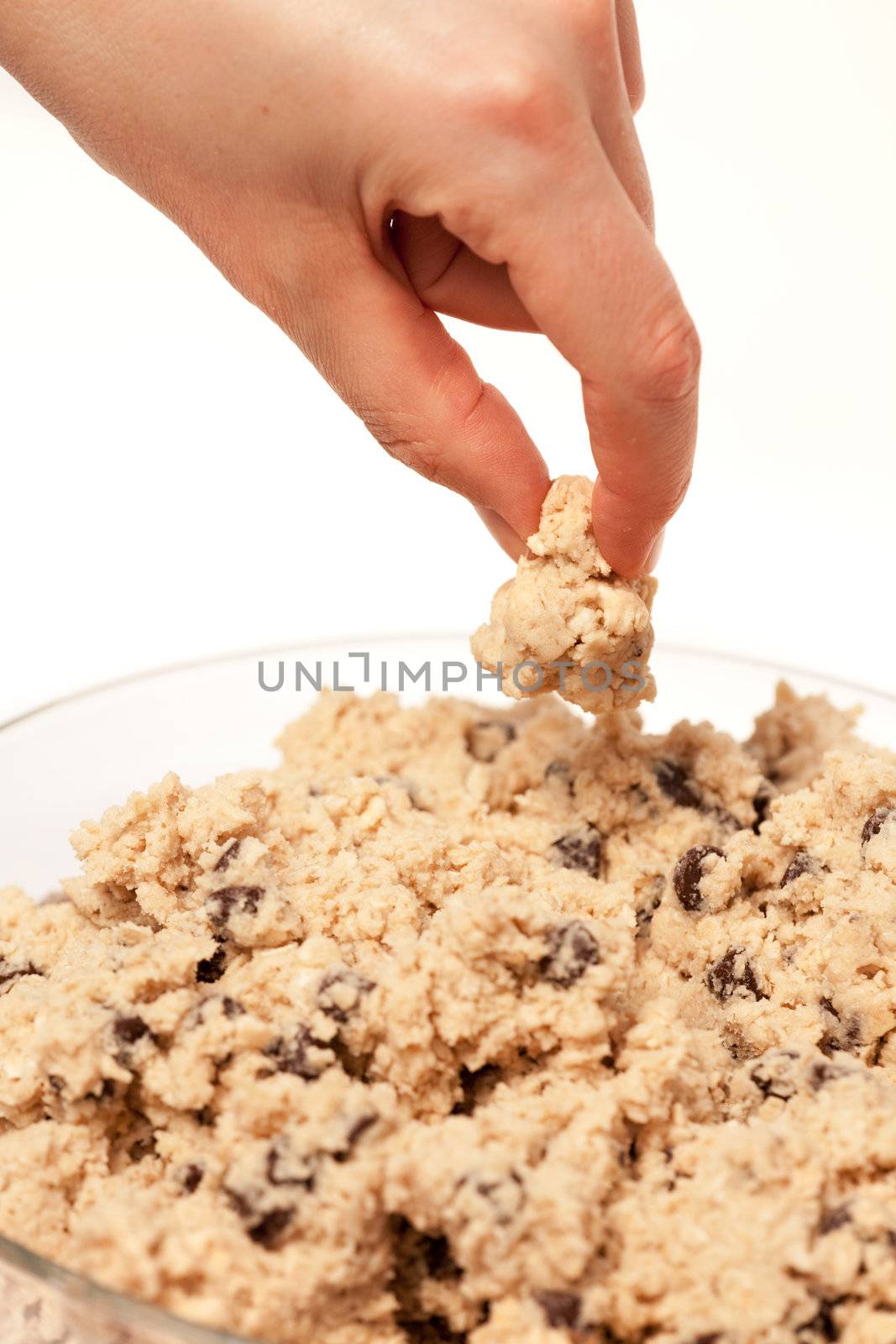 A hand grabbing a test taste of cookie dough