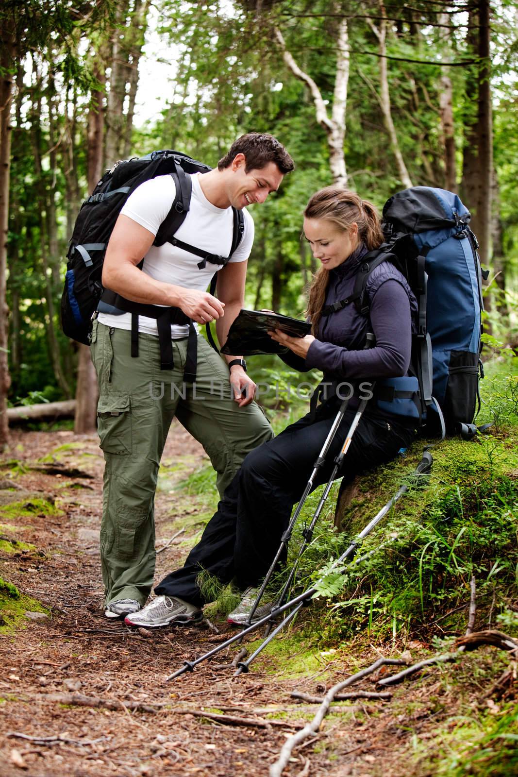 A couple on a backpacking camping trip looking at a map