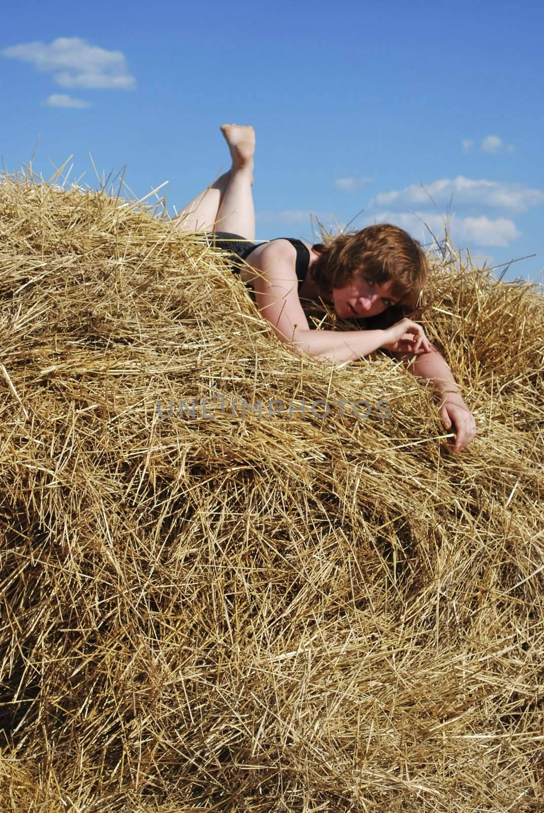 haystack and young woman on distant plan