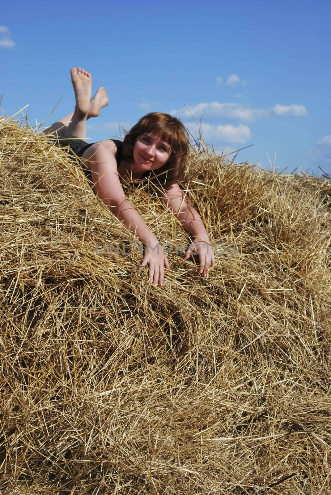 haystack and young woman on distant plan