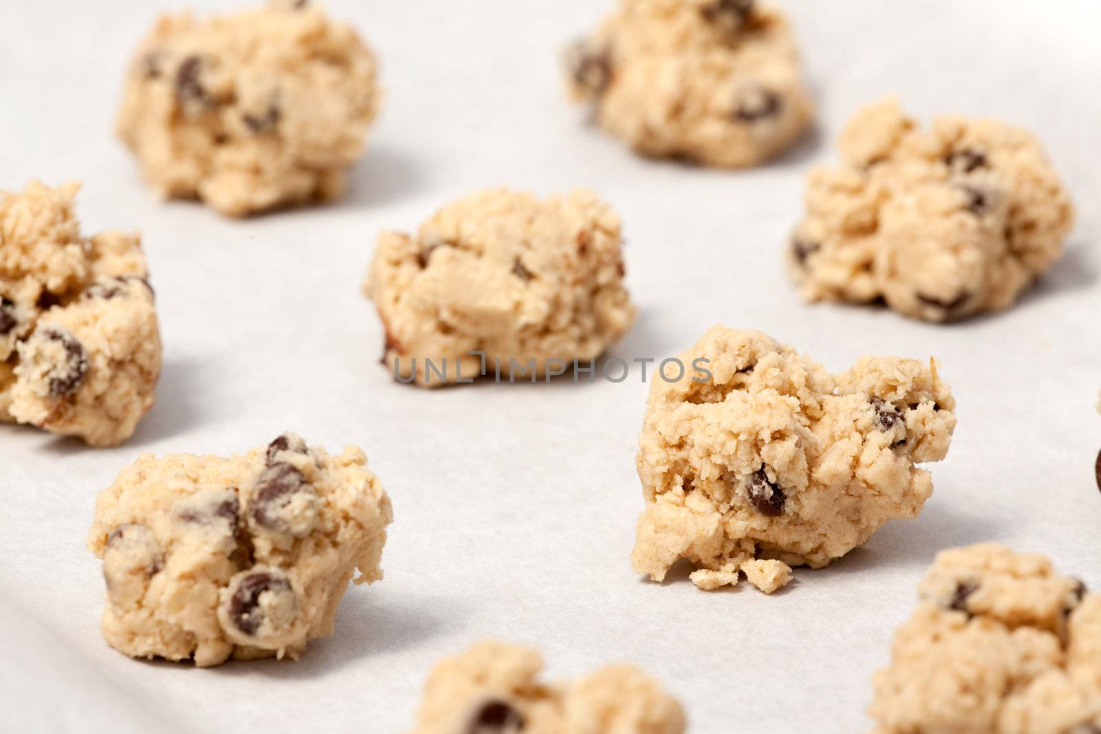 Raw cookie dough on a baking sheet with parchment
