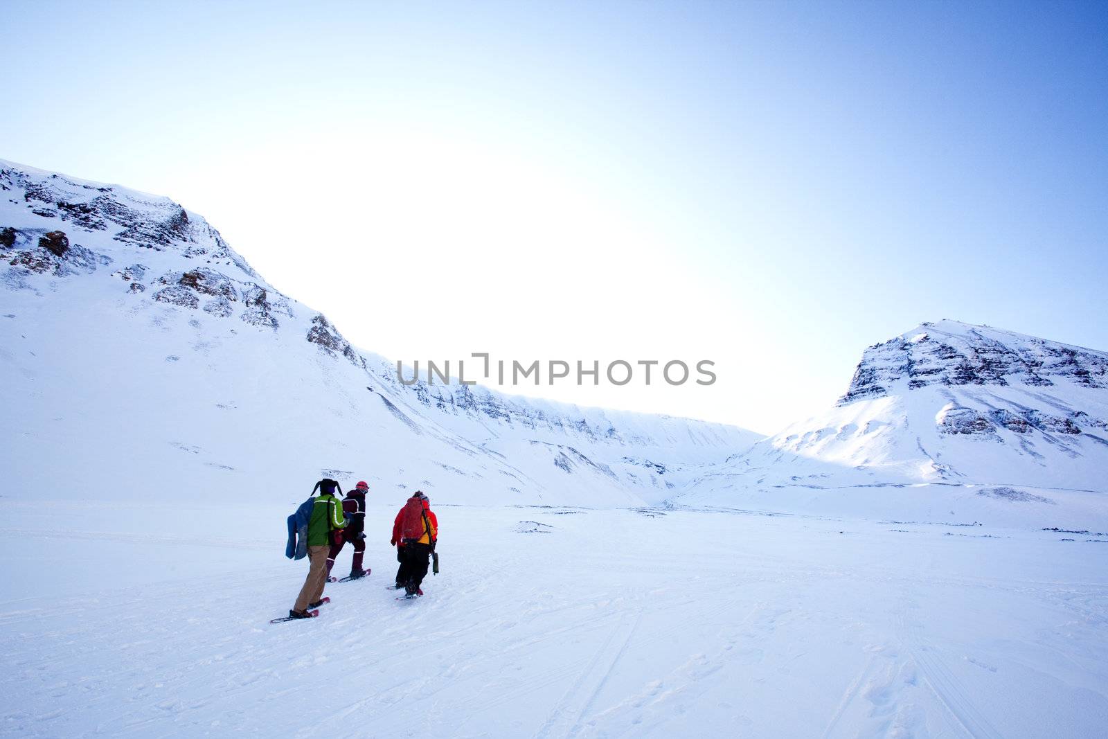 A group of people treking across a winter landscape