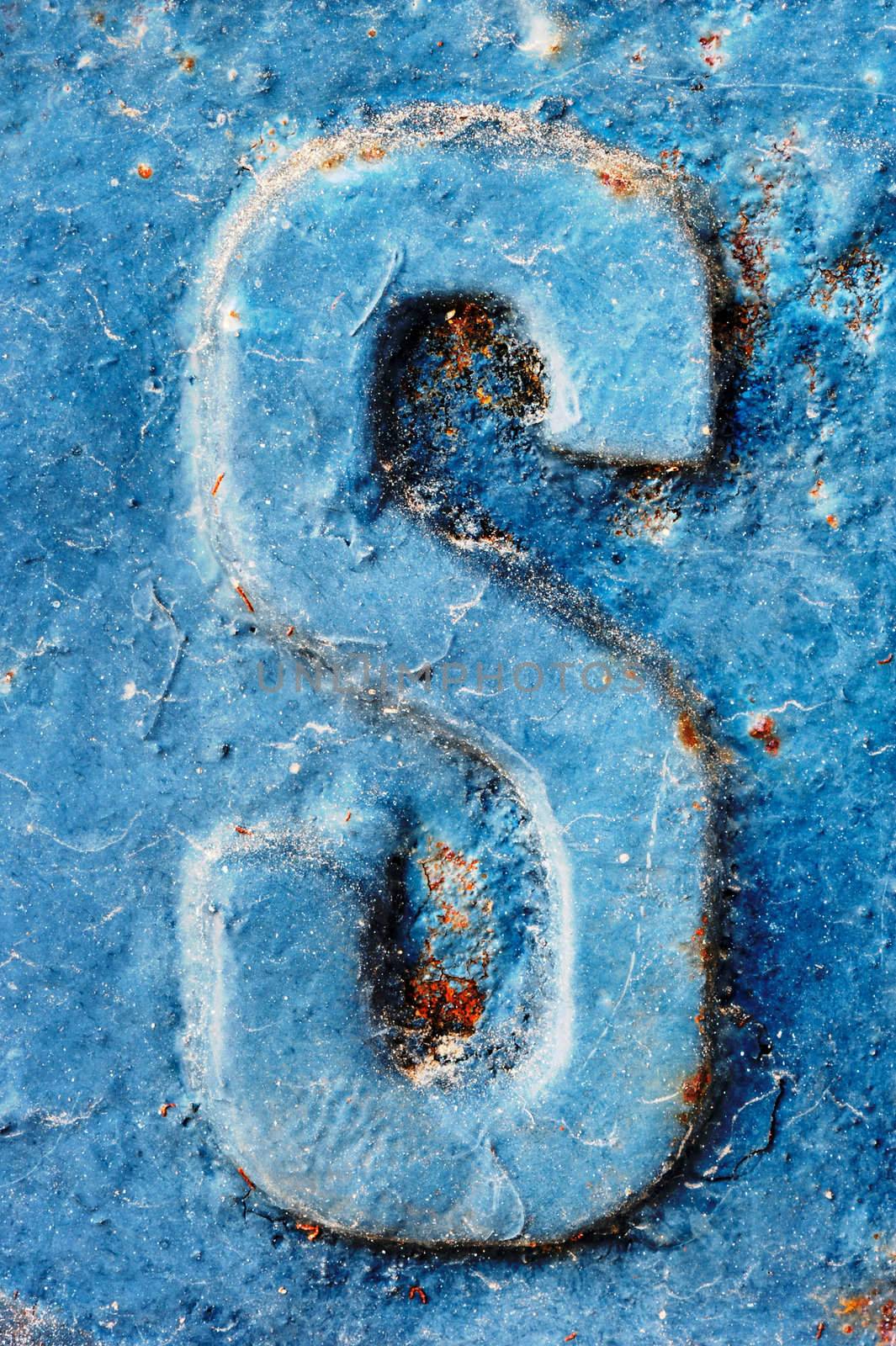 The letter S on a highly textured metallic blue surface