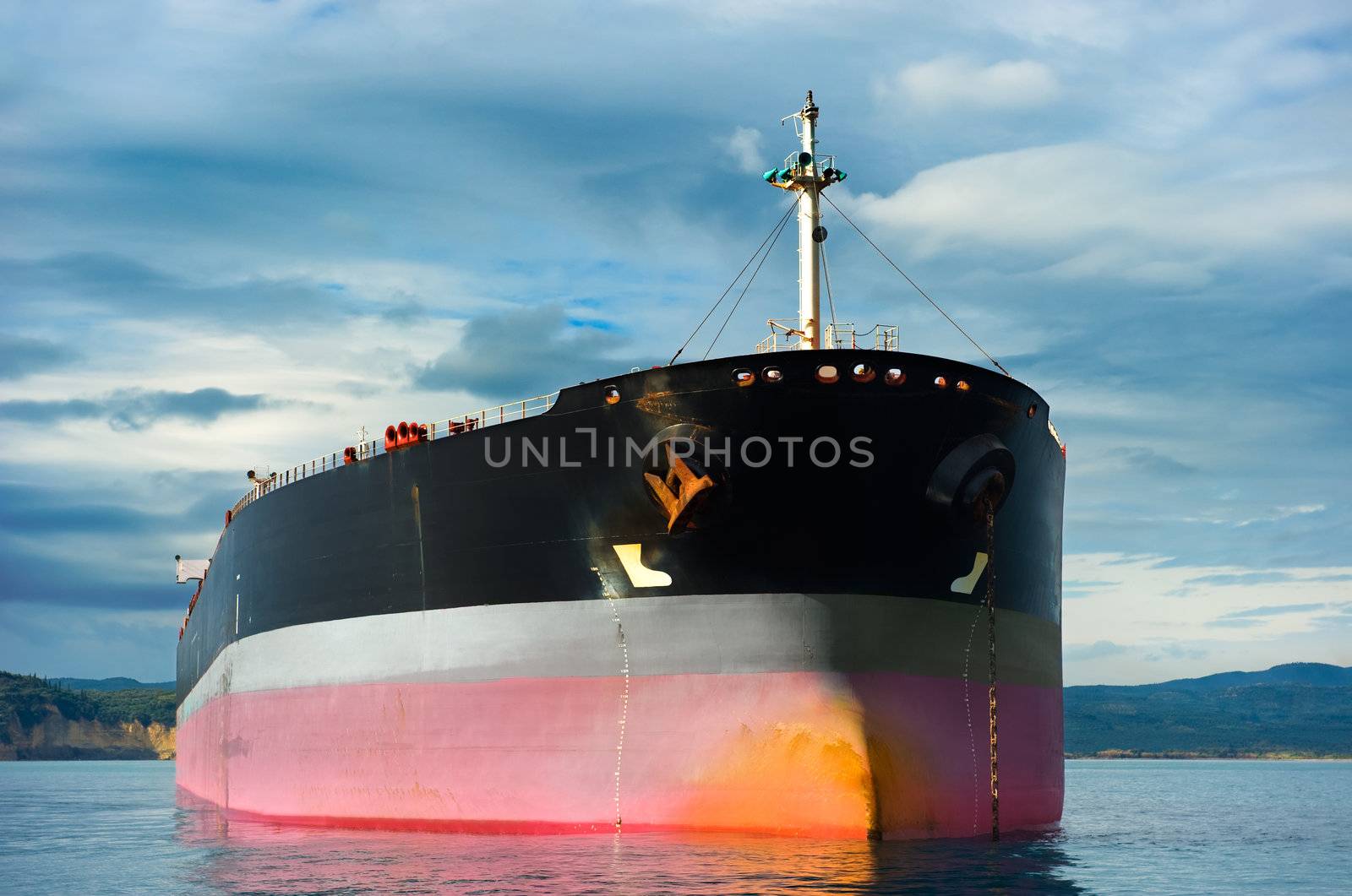Anchored empty tanker ship under an overcast sky