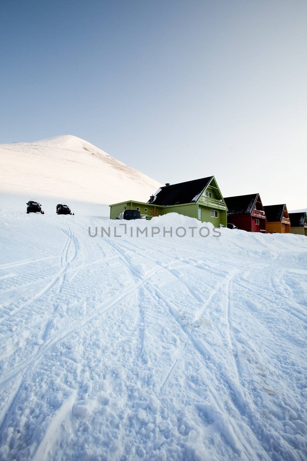 A detail of Longyearbyen, Svalbard, Norway.  A row of houses and a mountain in the distance.