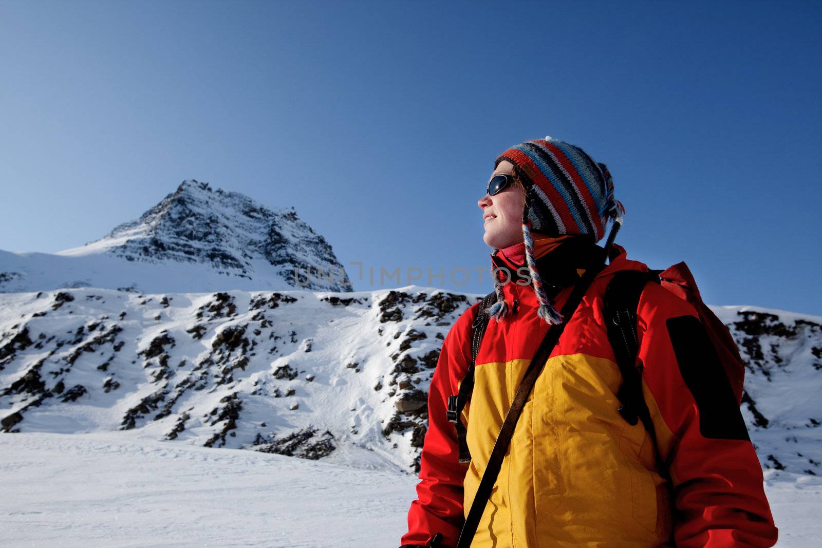 A portrait of a female adventurer against a mountain landscape