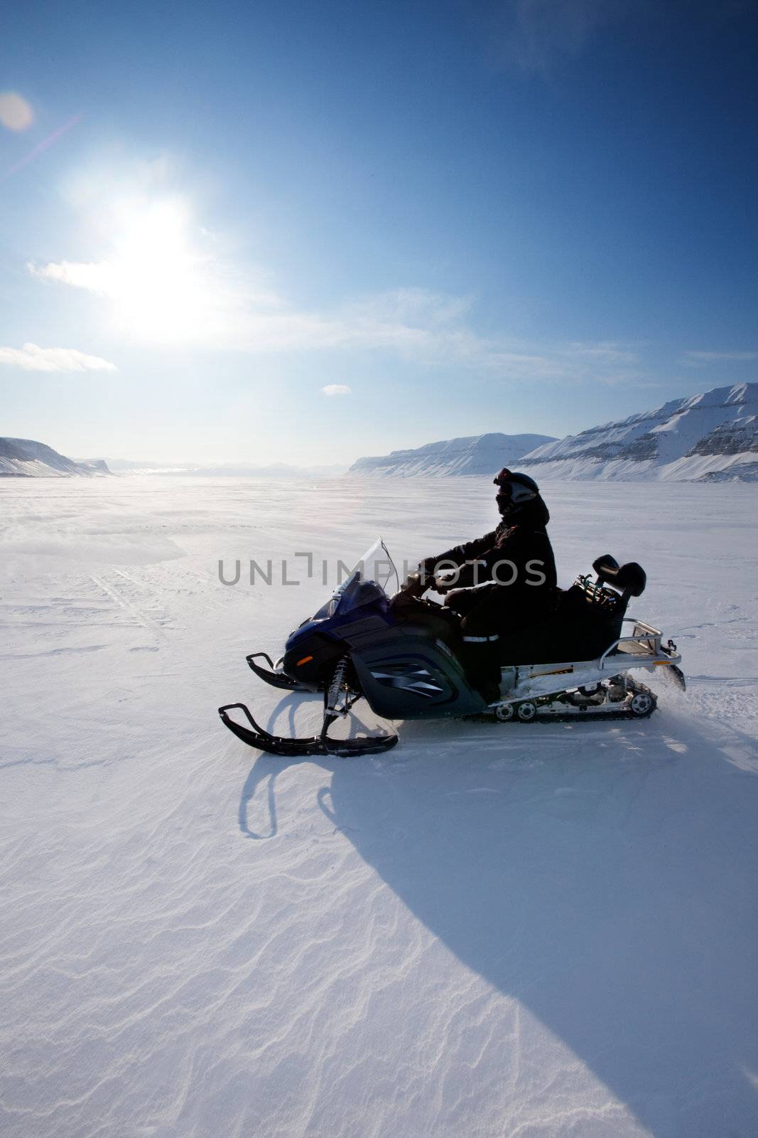 A snowmobile on frozen ice on a barren winter landscape