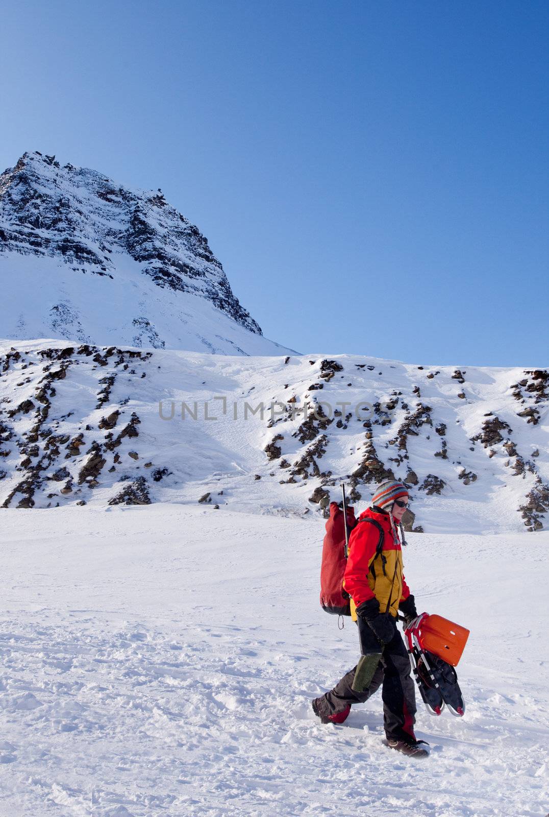 A female mountaineer against a winter mountain landscape